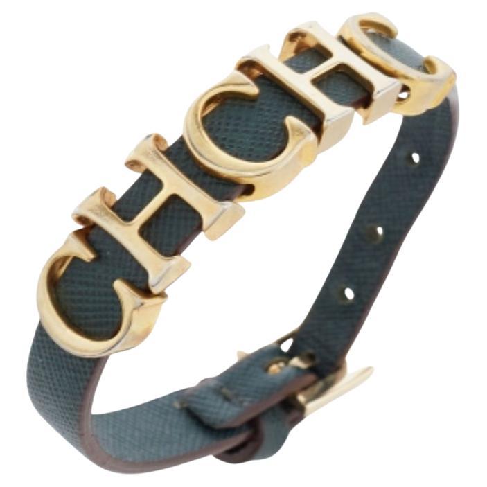 This beautiful wrap bracelet by CH Carolina Herrera is designed with gold-tone CH logo charms looped in forest green leather. It features a buckle closure with adjustment holes.