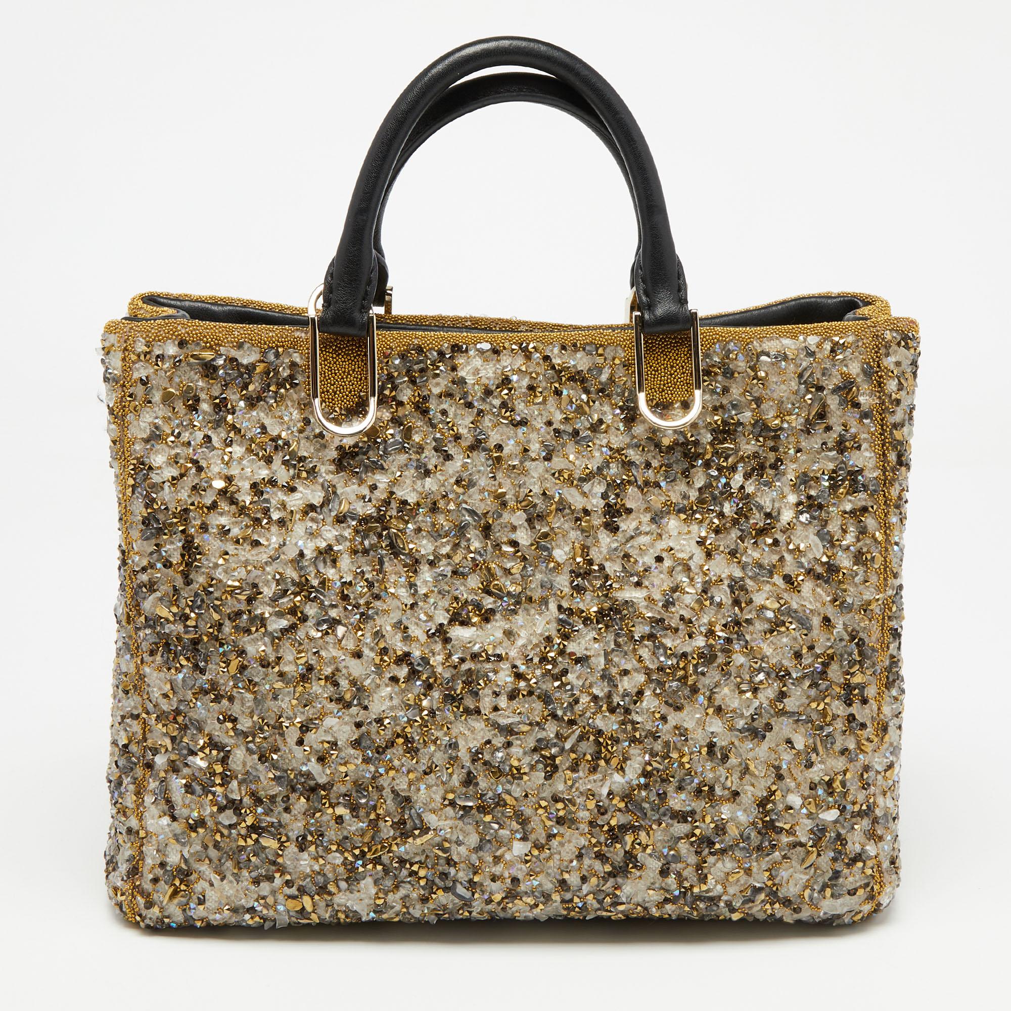 This Duchess tote by CH Carolina Herrera is crafted from leather and is beautifully decked with crystal embellishments all over. It features dual handles that open to a spacious interior to house your evening essentials.

Includes: Original Dustbag,