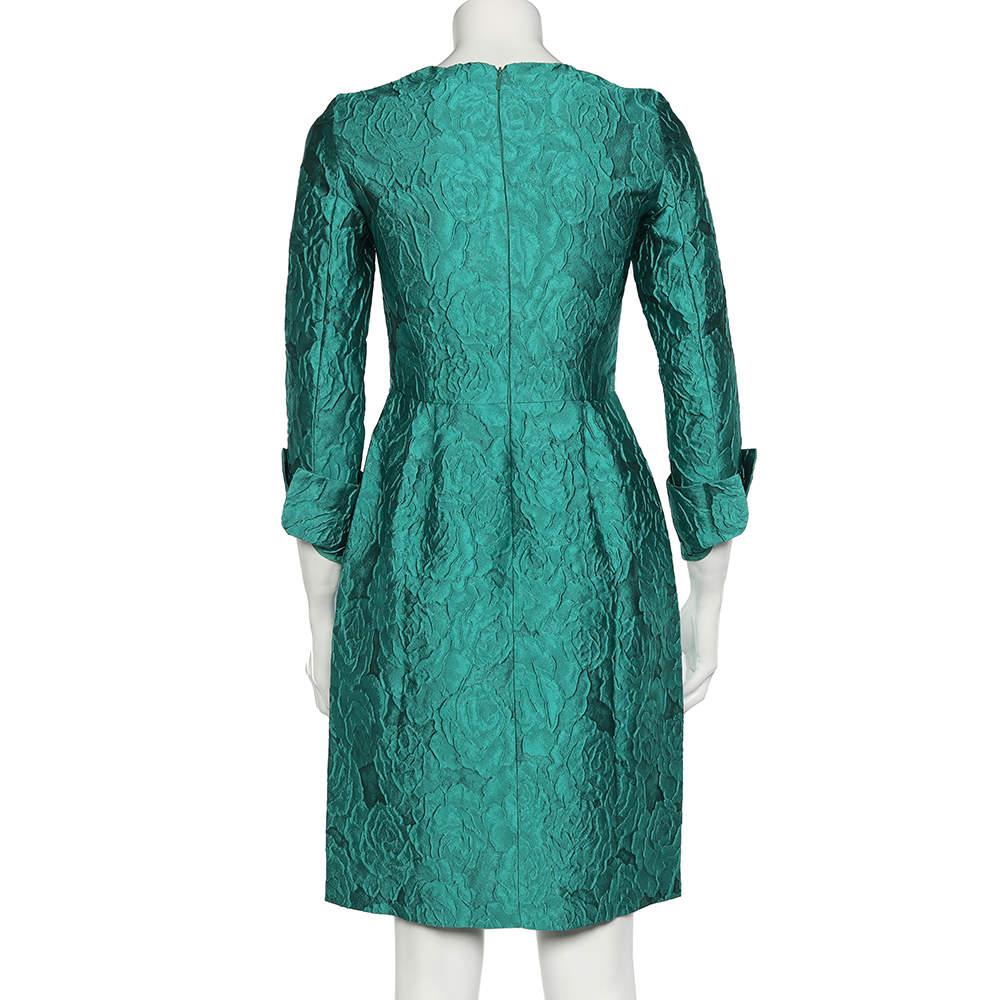 Dieses aufwändig geschneiderte Etuikleid von CH Carolina Herrera bringt Ihnen Glück, Eleganz und Luxus ohne Ende! Es ist aus grünem Seidenjacquard-Stoff gefertigt und zeigt sich mit langen Ärmeln. Sie ist mit einem Reißverschluss auf der Rückseite