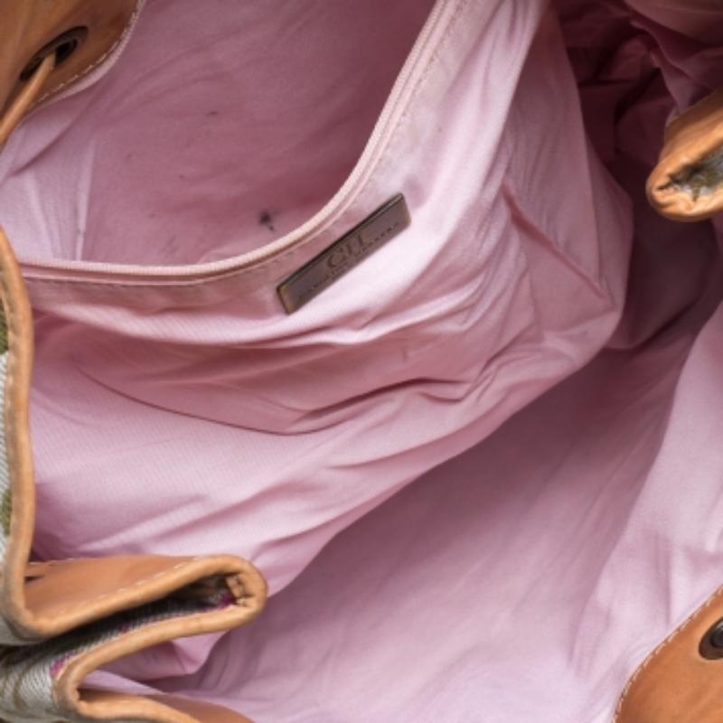 CH Carolina Herrera's tote is stylish, durable, and practical. Crafted from fabric and leather, it features beautiful embroidery in multiple hues, a drawstring fastening, and dual handles. The fabric-lined interior is spacious enough for your daily