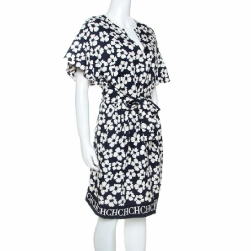Dieses Kleid von CH Carolina Herrera ist einfach umwerfend. Dieses Kleid glänzt mit einem wunderschönen Blumendruck auf dem marineblauen Hintergrund. Es hat einen eleganten Ausschnitt, einen charakteristischen Saum und ein Bindedetail in der Taille.