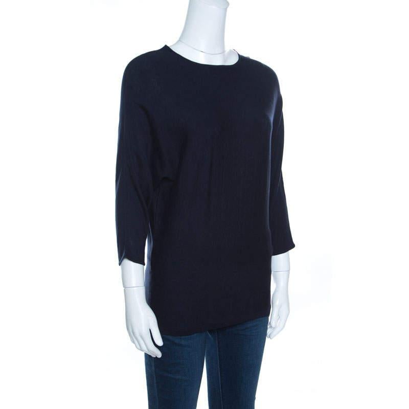 Simple and sophisticated is what defines this navy blue top from CH Carolina Herrera. It is made from wool blend fabric and features a round neckline dolman sleeves and gold toned button detailing on the shoulders. Pair it with denim and trendy