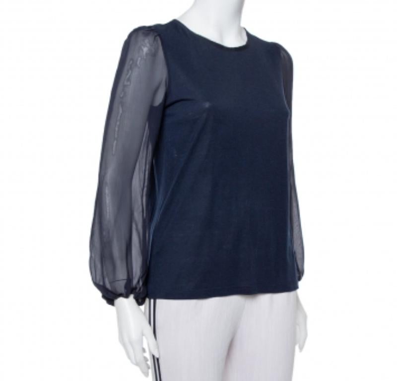 This designer top by CH Carolina Herrera skillfully merges fine craftsmanship and simple design. The women's navy blue top has long sheer sleeves, a round neckline, and a button closure at the back.