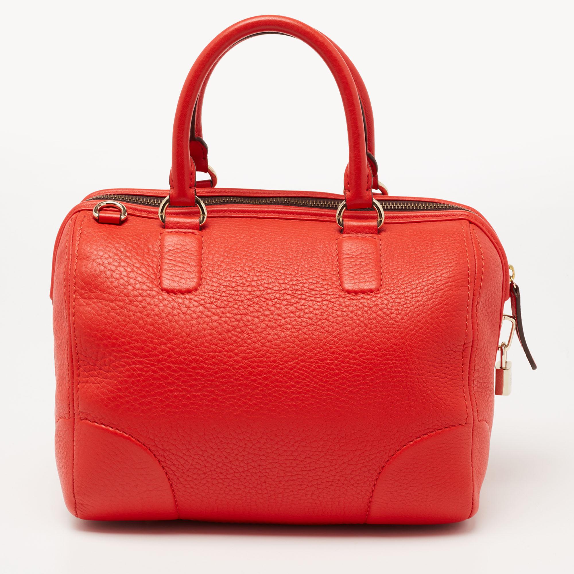 This CH Carolina Herrera bowler bag is contemporary and fresh. Crafted from orange leather, it flaunts the brand logo on the front. It can be carried using dual handles. The fabric-lined interior of this bag can dutifully hold all your