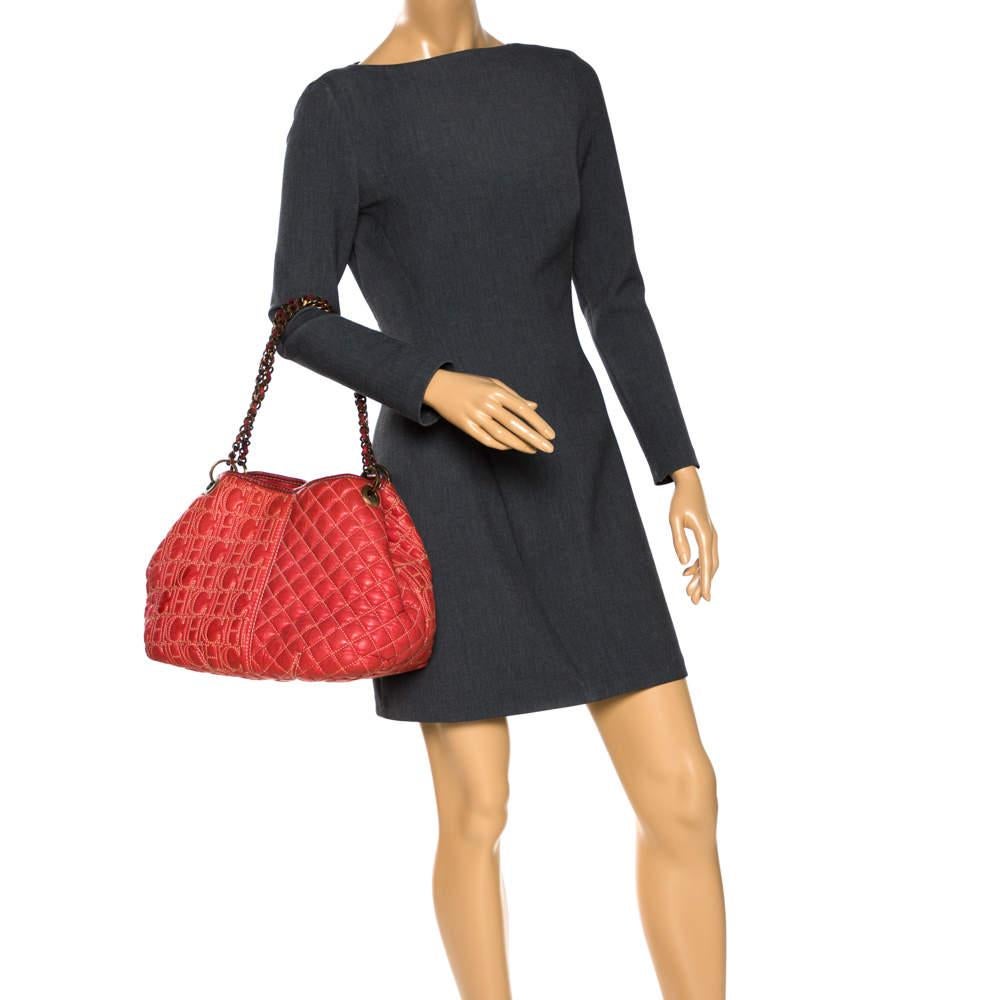 CH Carolina Herrera handbags are at the top of every woman's wardrobe. Incorporate a touch of glam into your look with this orange-hued handbag. Crafted meticulously from quality leather, it flaunts a monogram pattern on one side and a quilted