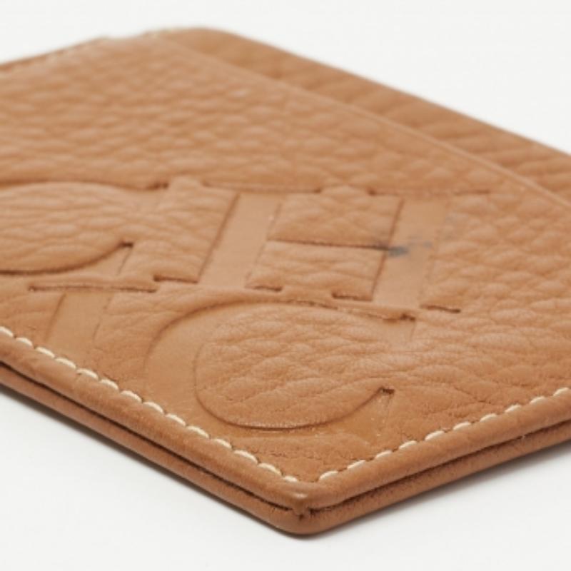 Designed smartly to hold cards or business cards, this CH Carolina Herrera card holder is stylish and functional. Crafted from tan leather, it features multiple card slots and logo detailing. It is sleek and can easily fit into your pocket.