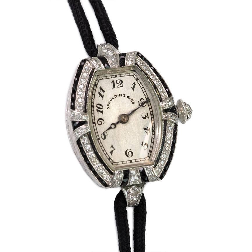 Art Deco diamond and onyx lady's wrist watch with tonneau-shaped face, in platinum.  Retailed by Spaulding & Co.  Movement signed C.H. Meylan, Brassus, Swiss, 18 jewels, 31888.