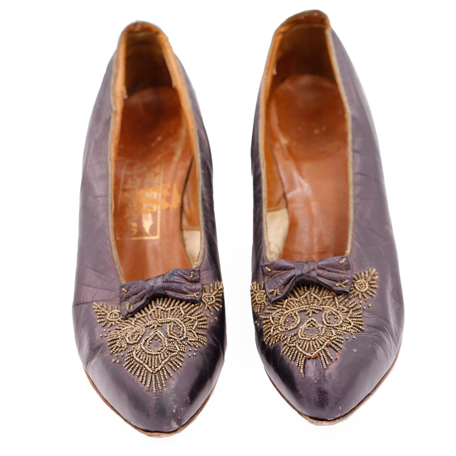 This is a rare pair of vintage 1910's purple leather beaded shoes from CH Wolfelt Co. The Bootery - Los Angeles, CAL.
These pretty Edwardian heels have lovely gold steel beads on the vamp and small beaded bows. The intricate beading creates a