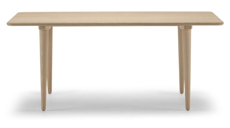 The CH011 coffee table was designed by Hans J. Wegner in 1954. Superbly crafted from solid wood, the gently-tapered legs add a sense of lightness to the sturdy table. With curved elements throughout, this versatile rectangular table breathes warmth