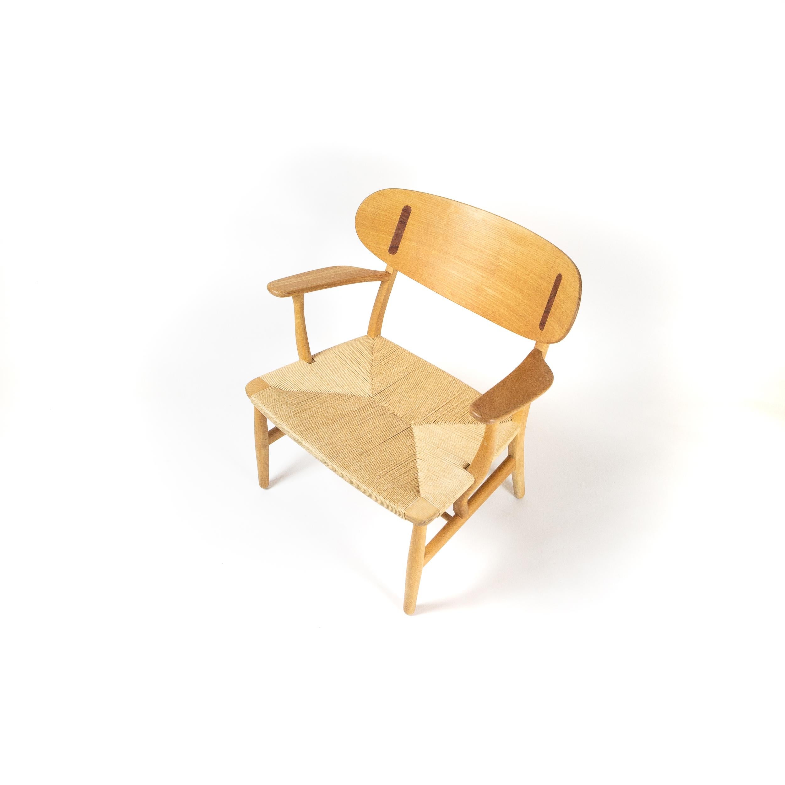 CH22 lounge chair by Hans J Wegner for Carl Hansen & Søn, Denmark. In excellent condition the chair is in beech with teak inserts and has been recently cleaned and treated with a soap finish. The paper cord seat is in excellent condition. This