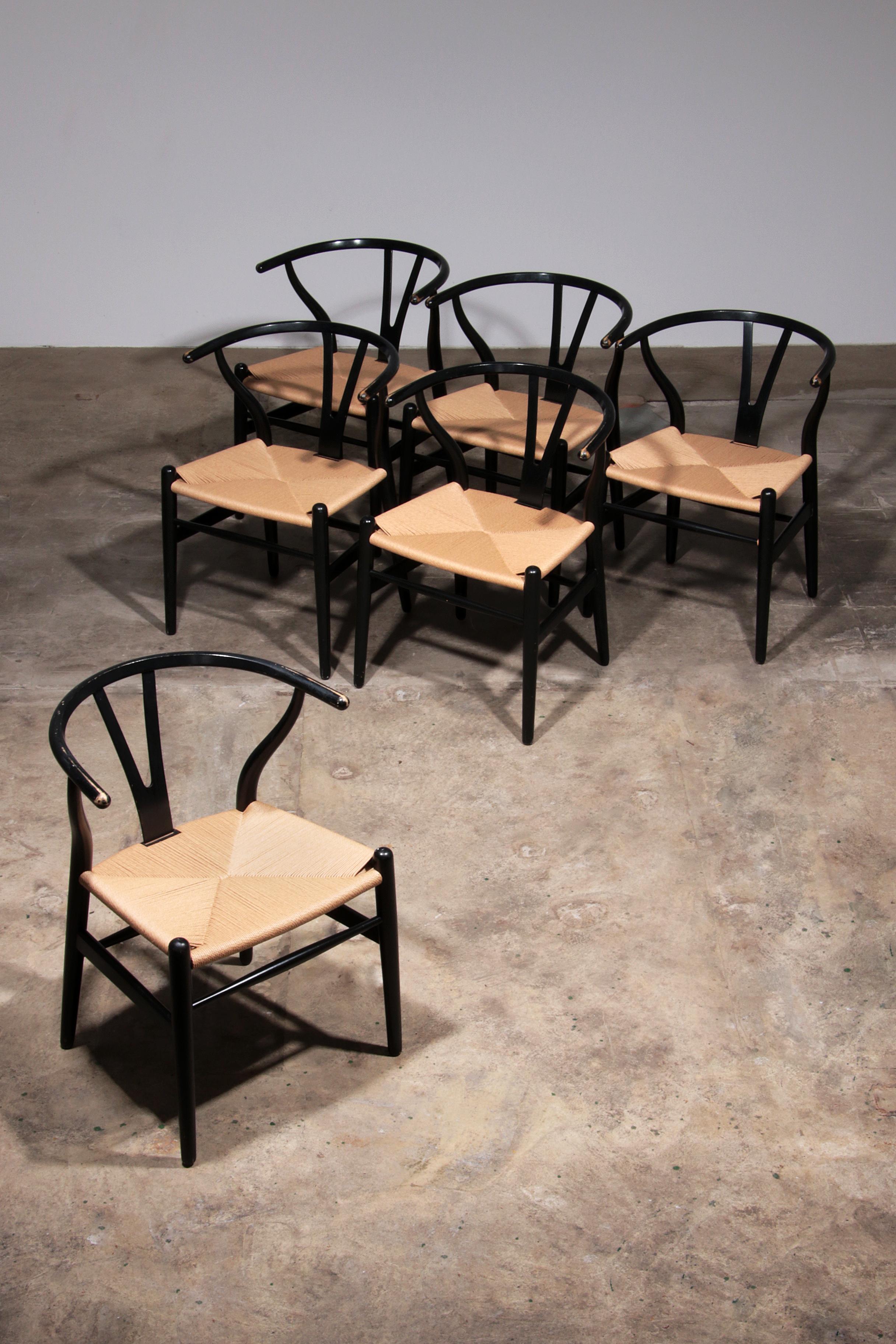 

This exquisite set of six CH24 Wishbone chairs, designed by Hans J. Wegner and manufactured by Carl Hansen & Son, showcases timeless Danish craftsmanship. Originally designed in 1949, these chairs feature black-painted beech frames with papercord