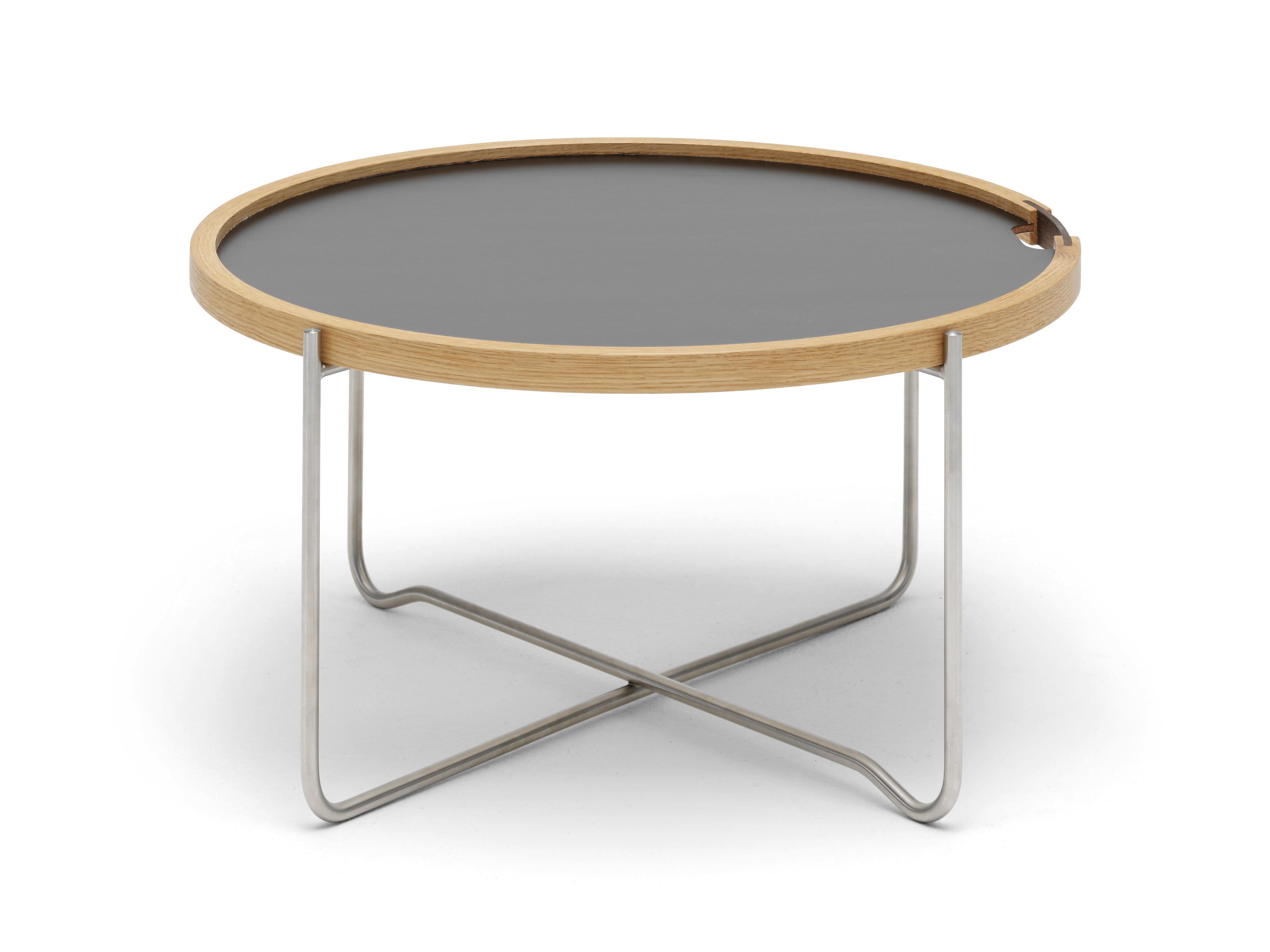 The CH417 tray table by Hans J. Wegner combines two parts, a reversible round tray and a collapsible base, into a smart, easy-to-store solution that is at once light and sturdy as well as practical and elegant. A natural oak rim contains the