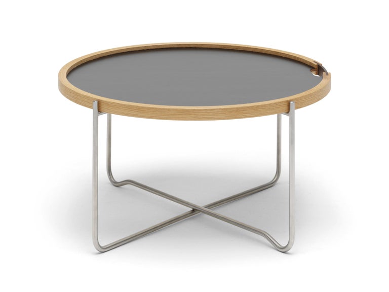 The CH417 tray table by Hans J. Wegner combines two parts, a reversible round tray and a collapsible base, into a smart, easy-to-store solution that is at once light and sturdy as well as practical and elegant. A natural oak rim contains the