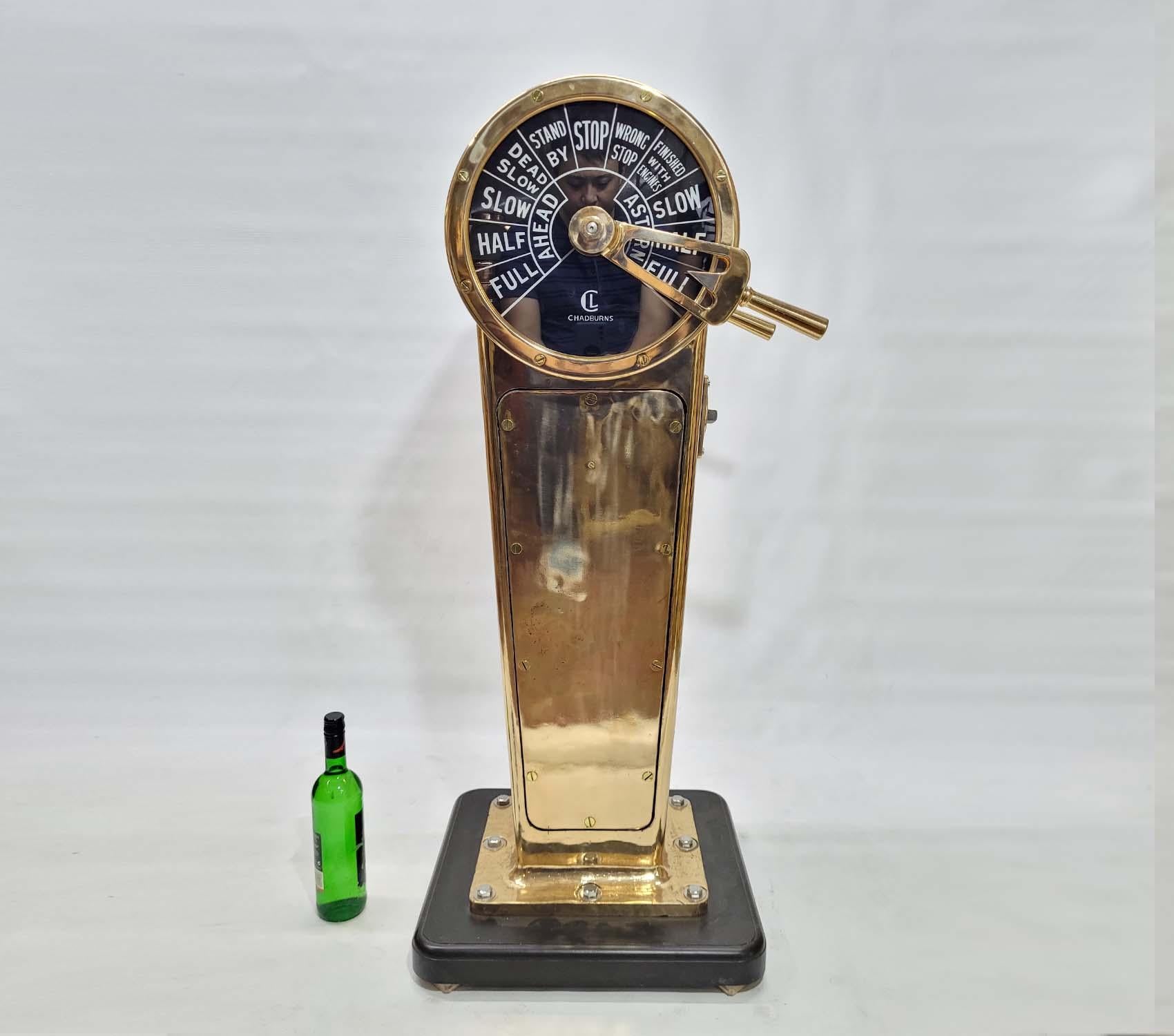 Solid brass ships bridge telegraph by the venerable English maker Chadburns of Liverpool England. Twin faceplate design with ahead and astern commands. Meticulously polished and lacquered. Mounted to a thick wood base. Art deco style with a tapered