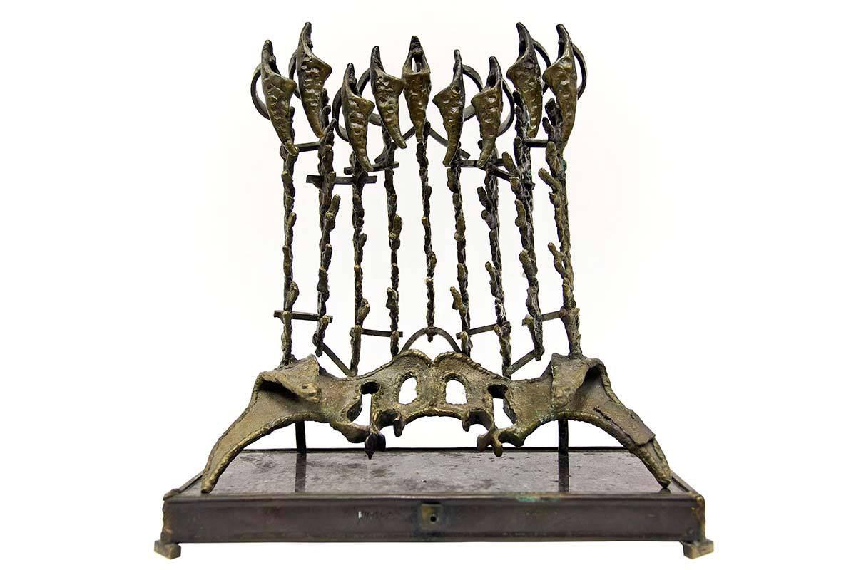 In this Menorah Chaim Hendin takes a personal approach, and turns it into a more anatomical, almost pelvic, looking piece of artwork. The sculpture is rich in texture and the candle holders have a vertebrae look to them. The Menorah is placed on a