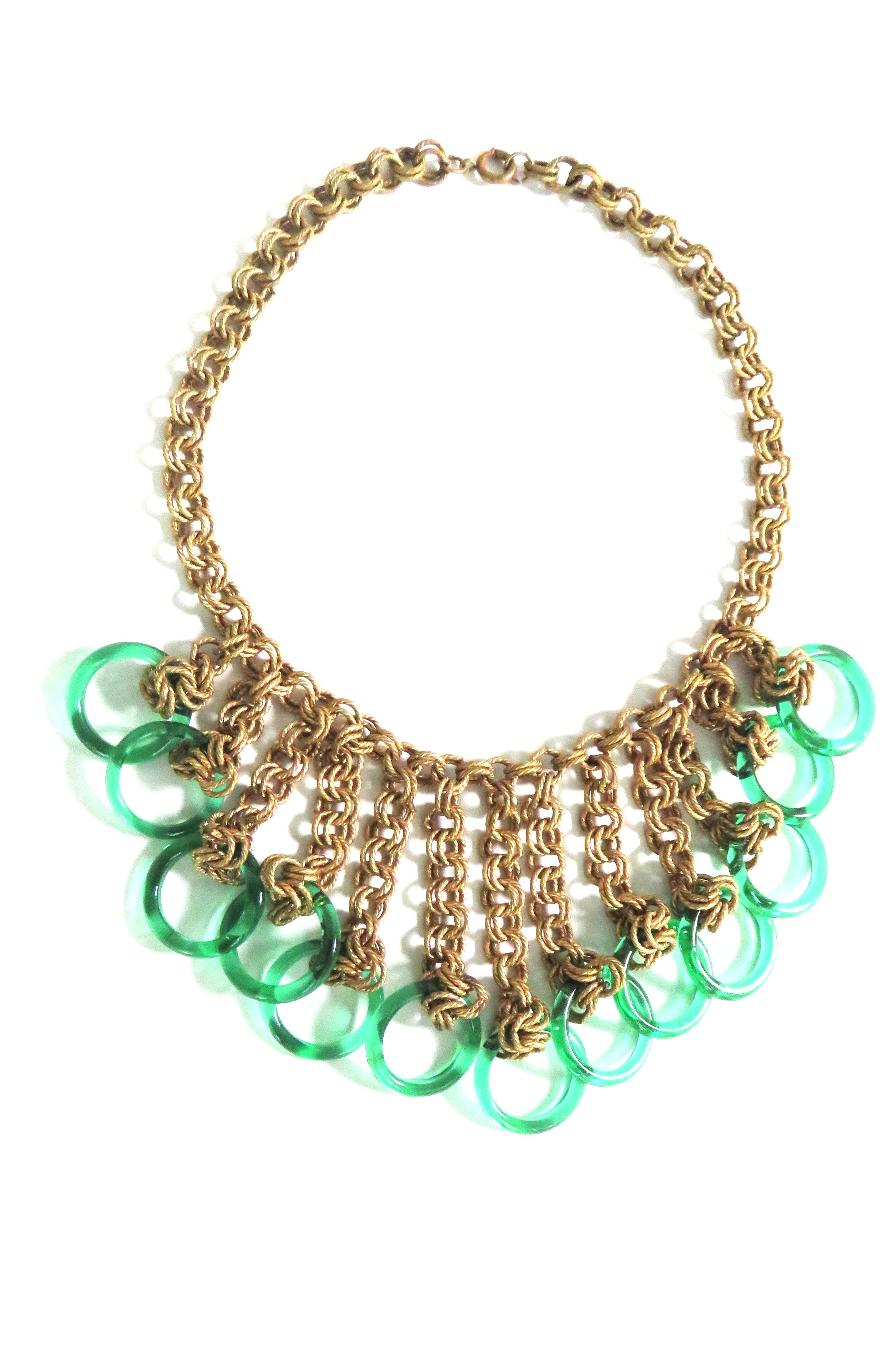 A gorgeous gold chain choker with green circles. The gold interwoven rope chain has a center front gradated chain bib with 1