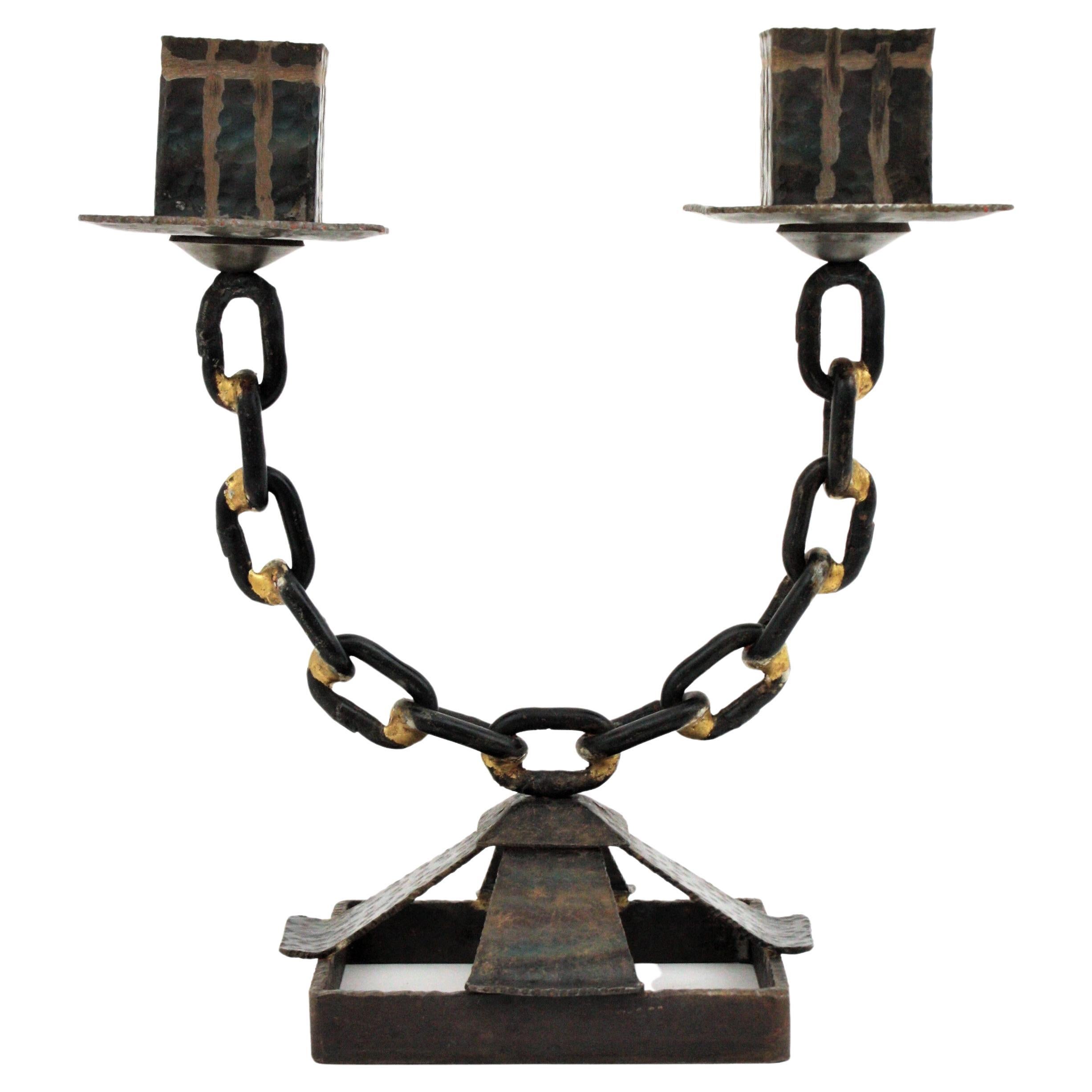 Spanish Brutalist Candle Holder with Chain Link Motif, 1950s.
Beautiful hand forged candlelabra with two arms chain link design standing on a four footed squared base.
It has an interesting design combining Brutalist and Gothic accents.
Entirely