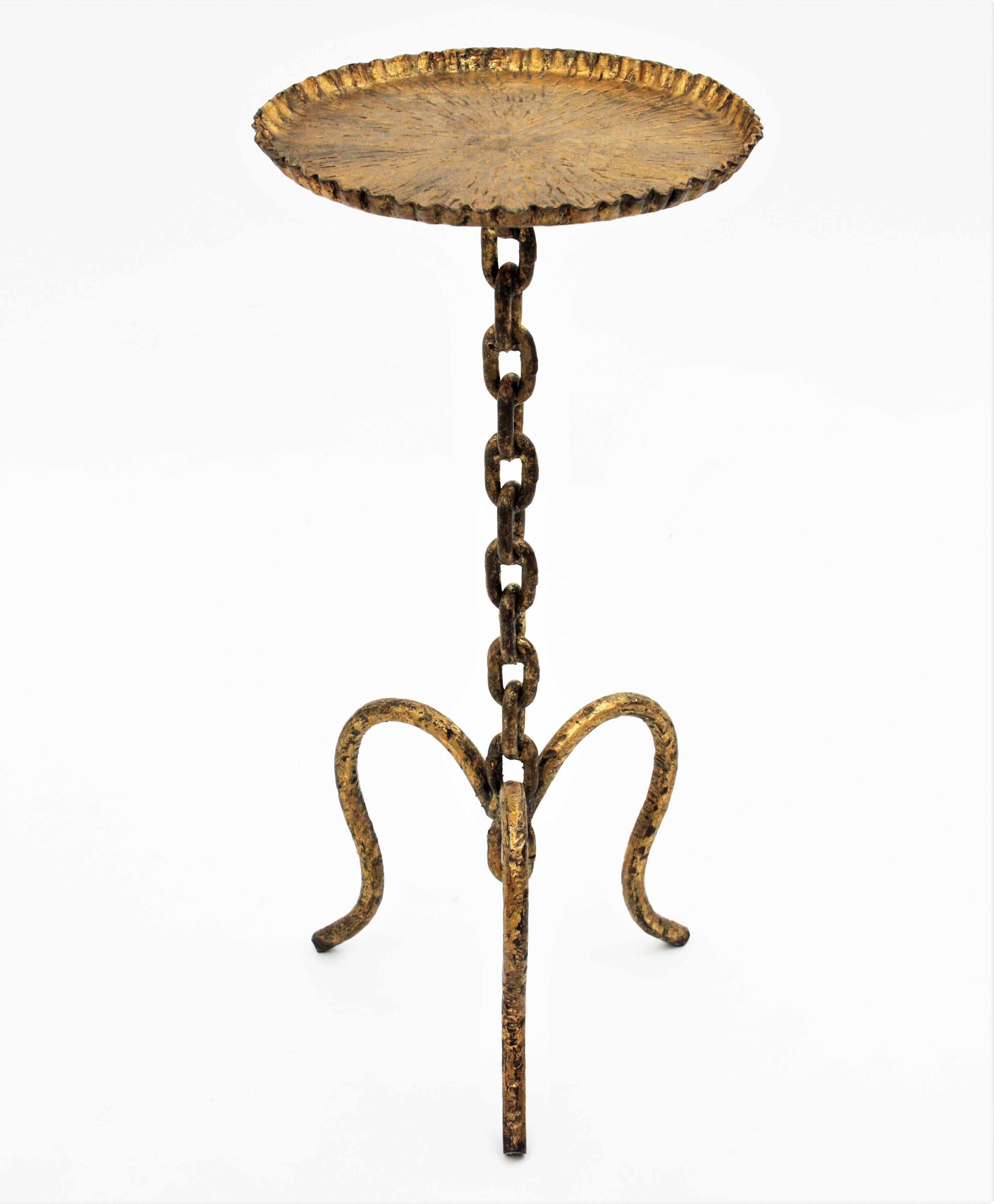 Spanish gilt wrought iron drink table Guéridon / side table with chain link motif, 1930s-1940s.
Beautiful hand forged iron occasional table with chain link stem and wavy edged top standing on a tripod base.
This Guéridon pedestal table has an