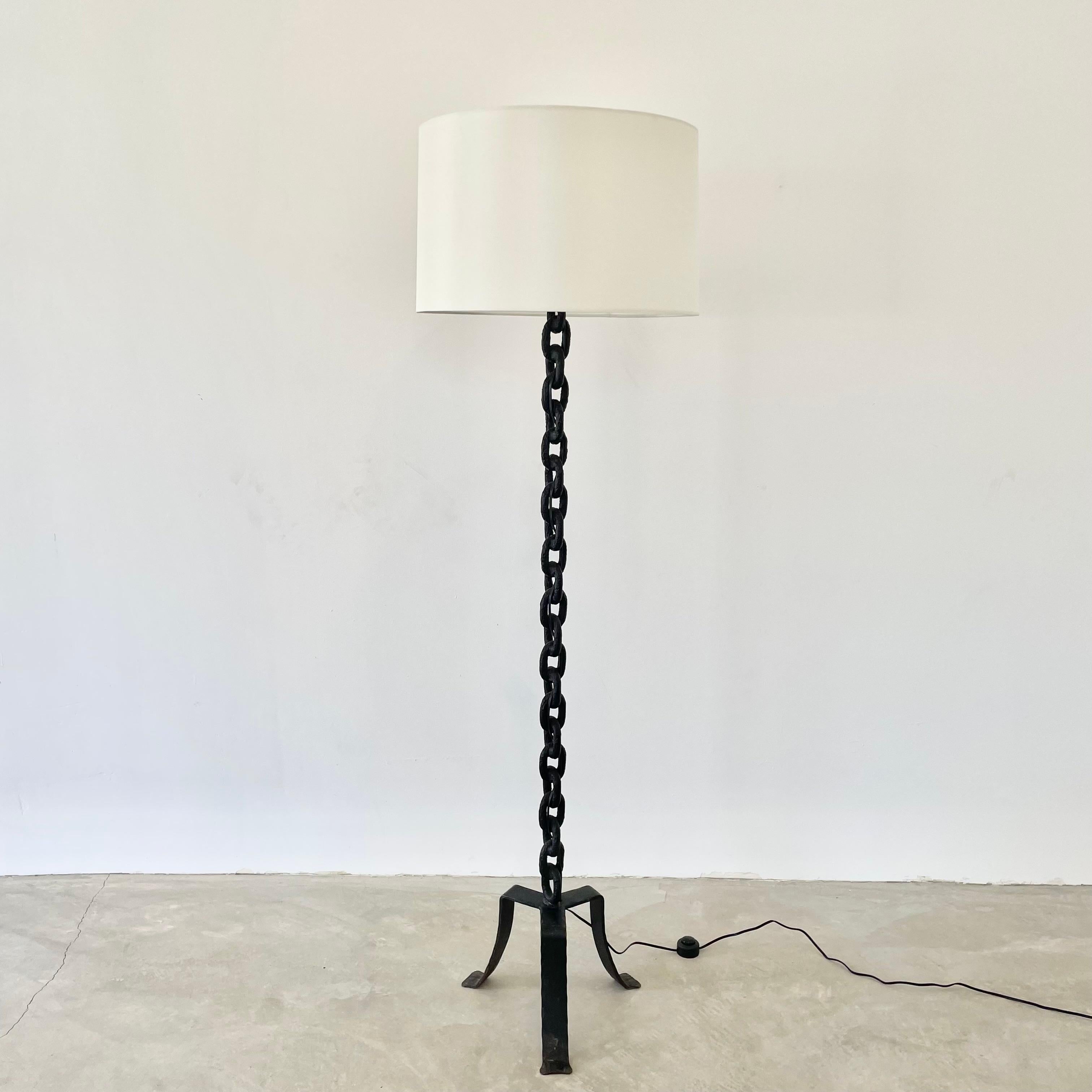 Brutalist iron chain link floor lamp, made in 1950s France. Just over 5.5 feet tall. Extremely heavy and substantial lamp. Tripod base with rustic iron boat chain welded together and painted in a matte black. Features a new custom silk shade with