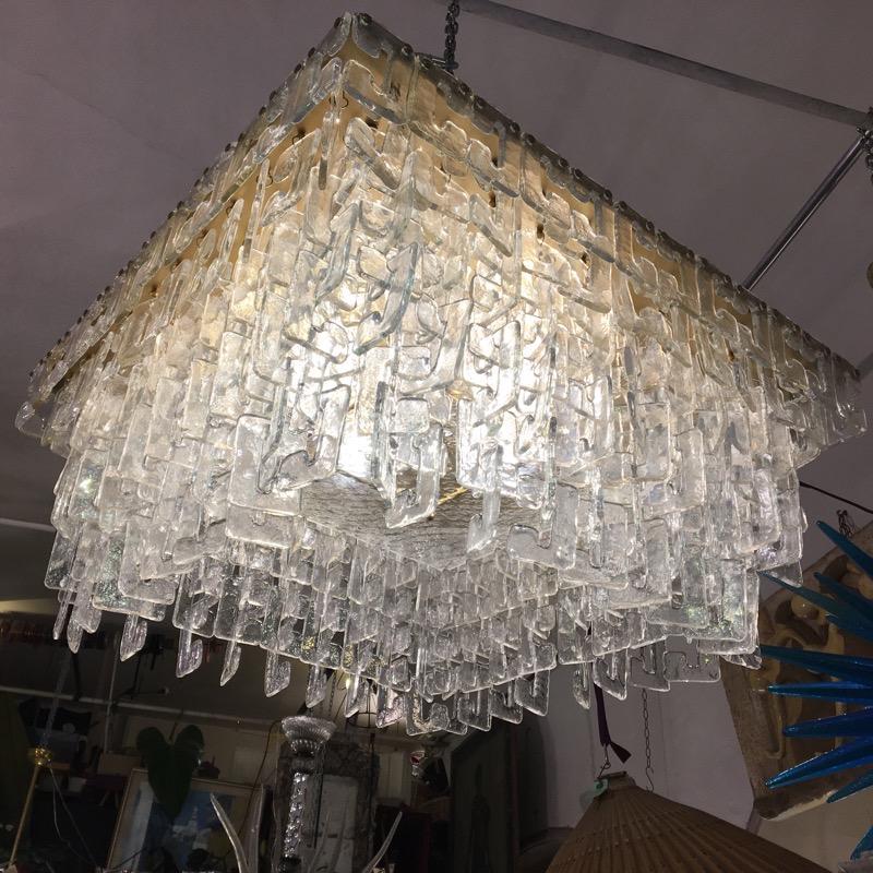 Chain link Murano C-shaped clear glass chandelier and brass structure.
The hand blown clear glasses hook on each other with waterfall effect.
The chandelier weighs about kg 130 and it has 4 light bulbs.
 