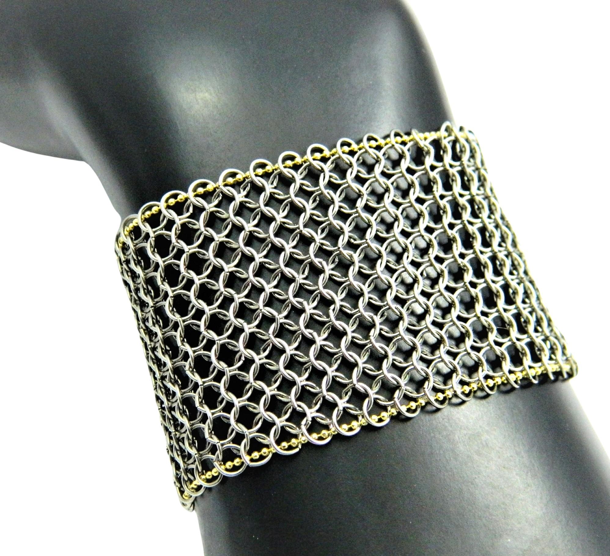 A one of a kind handmade Chainmail cuff Bracelet with 14K accents. The Stainless Steel Chainmail is machine made and cut into a strip. A 14K chain is woven into the chainmail at each border. The chain is diamond cut and really shows a sparkle