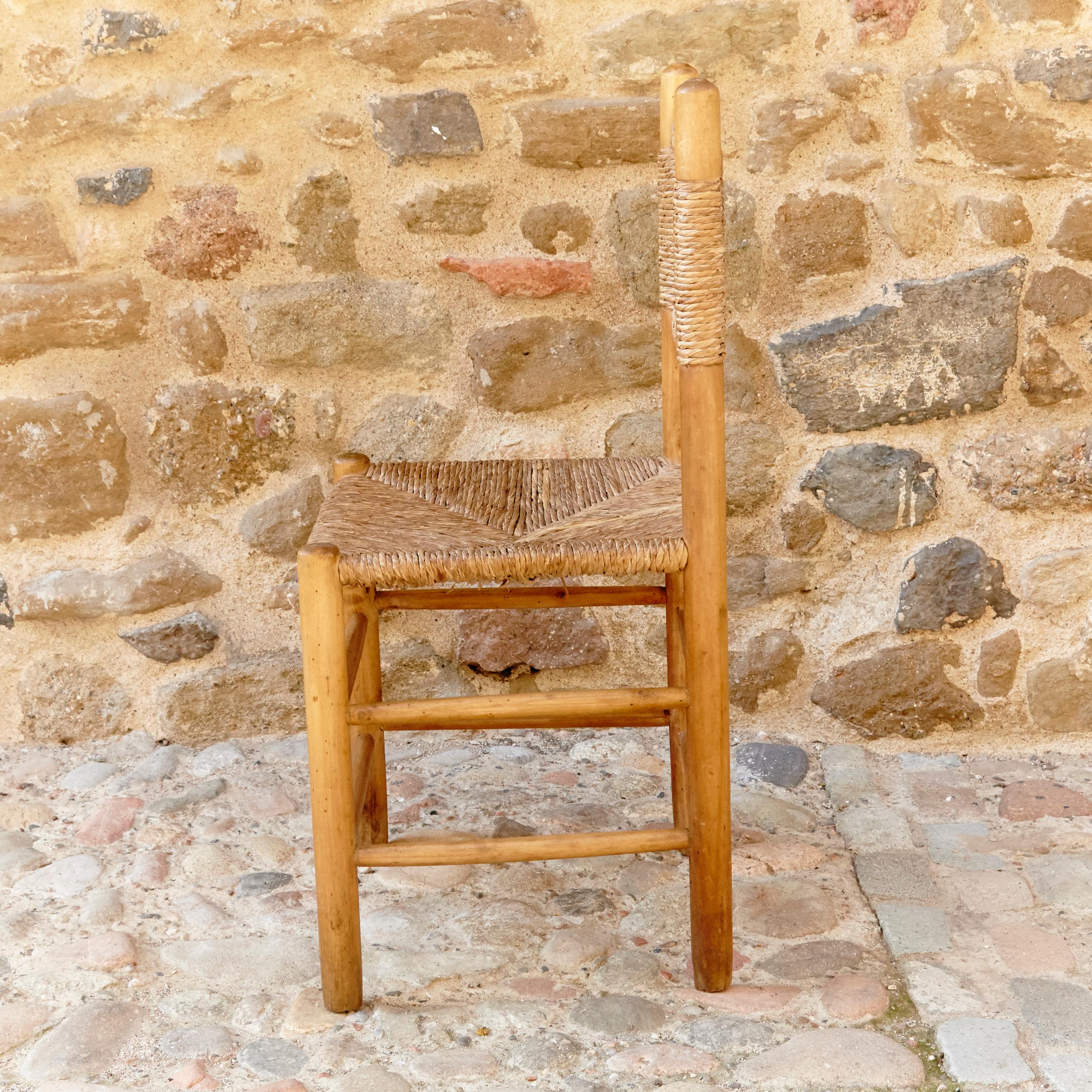 Chair designed in the style of Charlotte Perriand, made by unknown manufacturer.

Wood and rattan.

In good original condition, with minor wear consistent with age and use, preserving a beautiful patina.