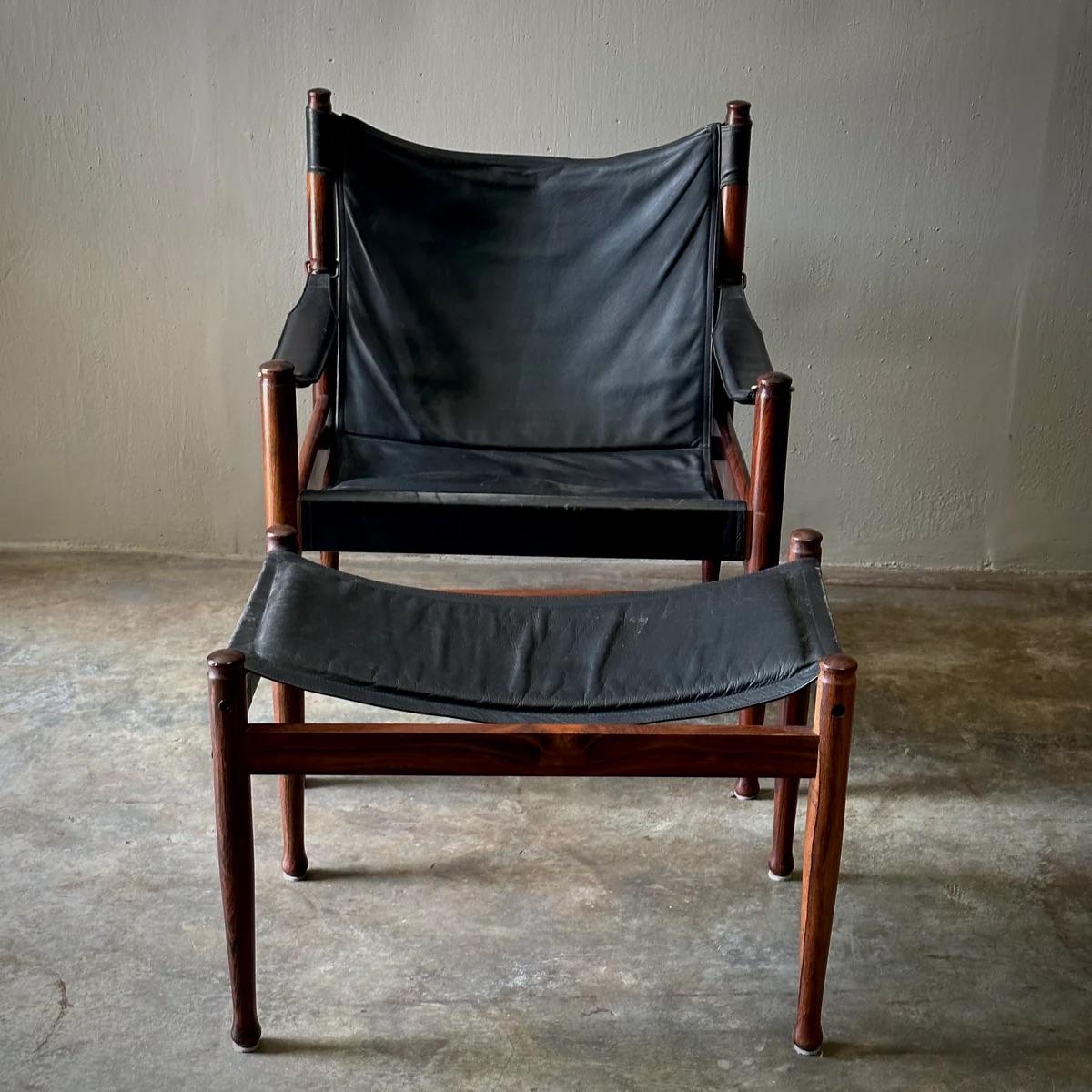 Questa iconica sedia safari e il pouf abbinato, disegnati da Erik Worts per Niels Eilersen, combinano una lussuosa pelle nera con una ricca struttura in palissandro. Le linee pulite e la struttura minimalista del design sono completate dal calore