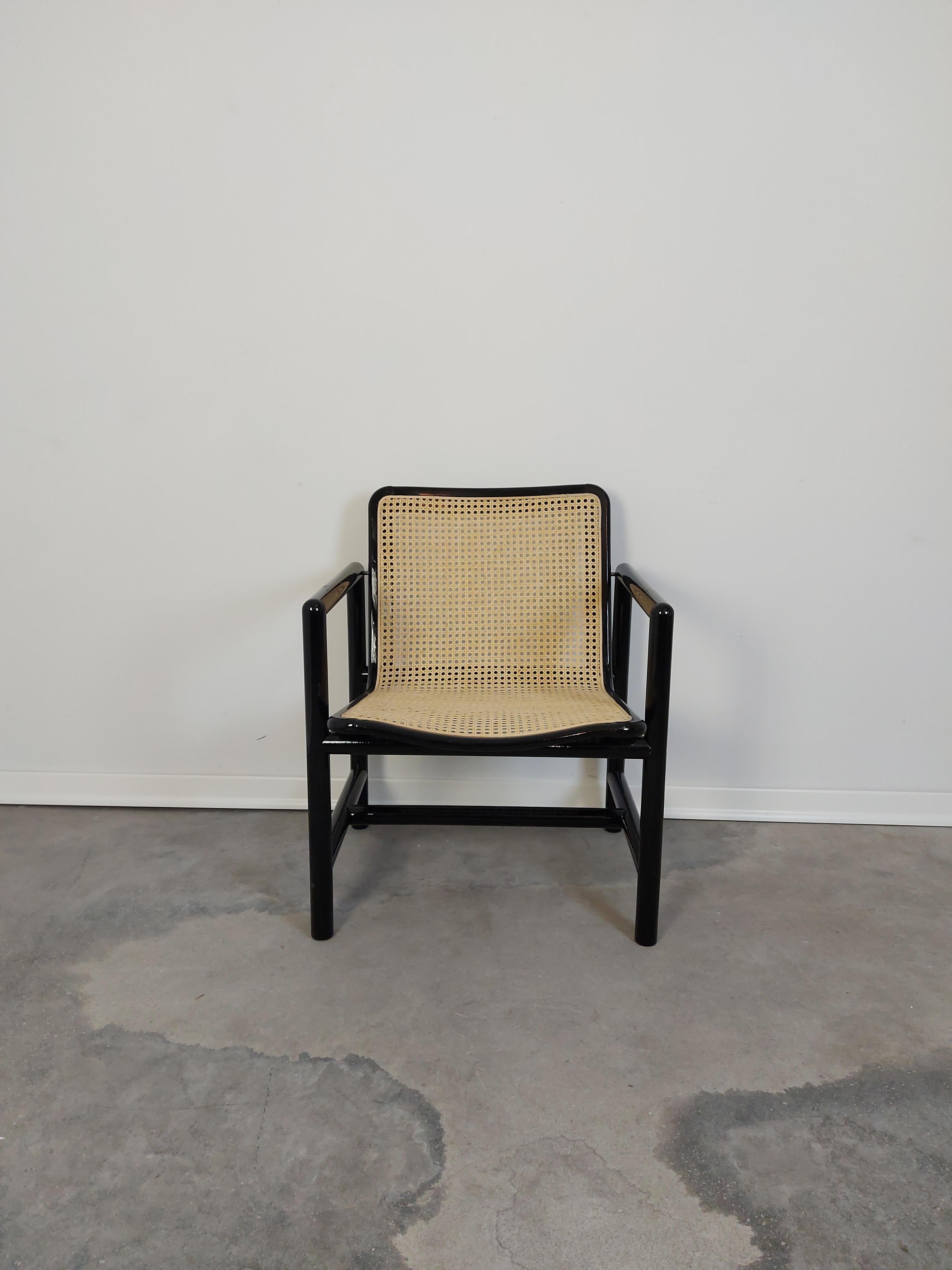 Dining chair produced by Stol Kamnik, Slovenia. Age: 1980s. It is made of a wooden frame painted in black with glossy finish and a brown cane seat. The chair was designed by Slovenian designer Branko Ursic in 1982 and produced by Stol Kamnik. The