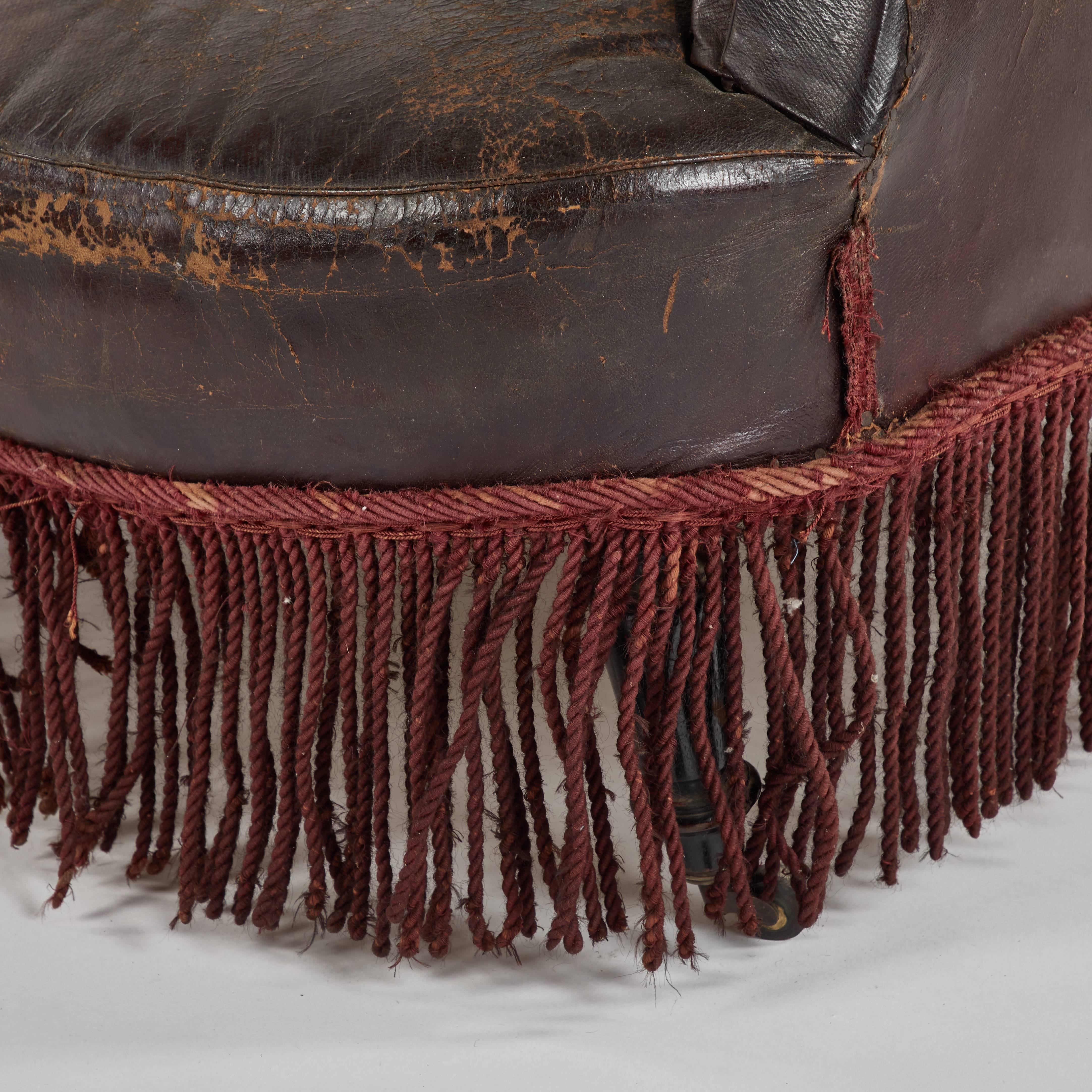 Early 20th century French leather armchair with fringe. 