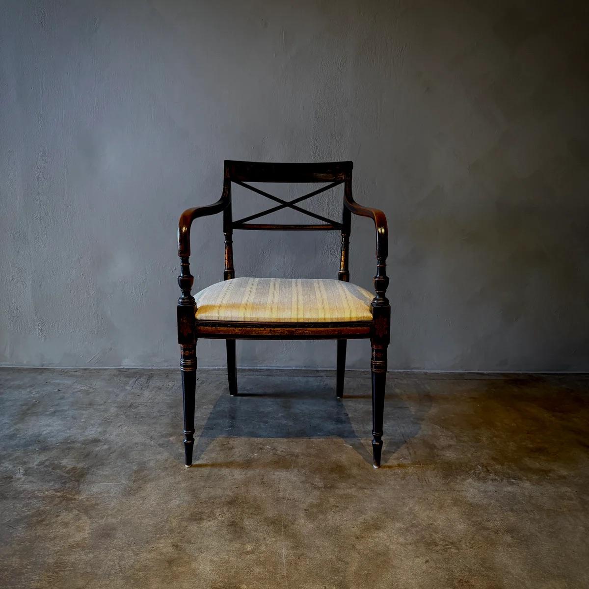 Este sillón ebonizado de la Inglaterra de 1820 muestra una exquisita artesanía con su decoración original, sus reposabrazos elegantemente curvados y sus patas finamente detalladas. La silla está tapizada en un tejido rayado y texturizado que