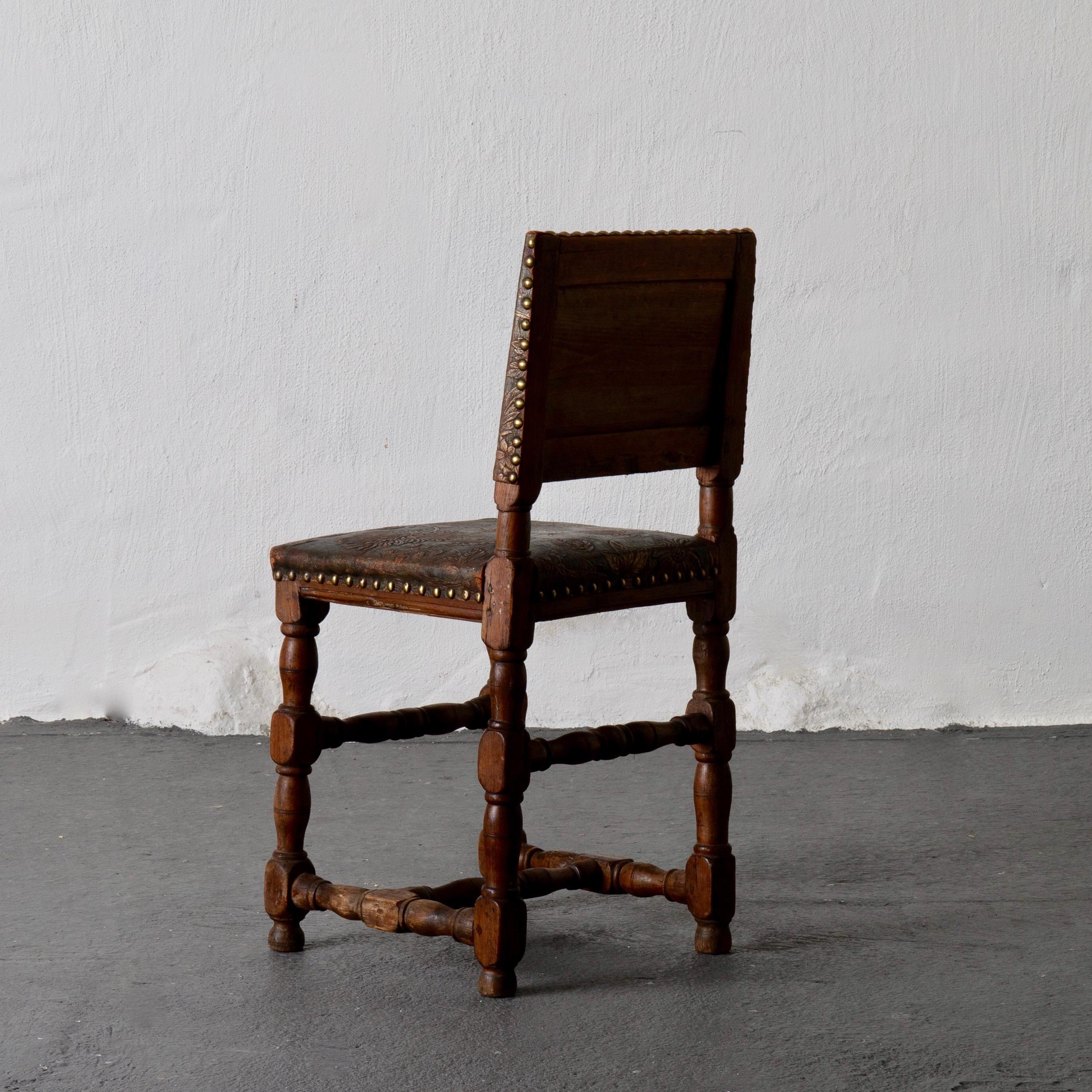 Chair Swedish Baroque oak gilt leather Sweden. An exquisite side chair made during the Baroque period in Sweden 1650-1750. Frame made from dark oak. Upholstered in a gilt leather with flowers, birds and leaves.

 