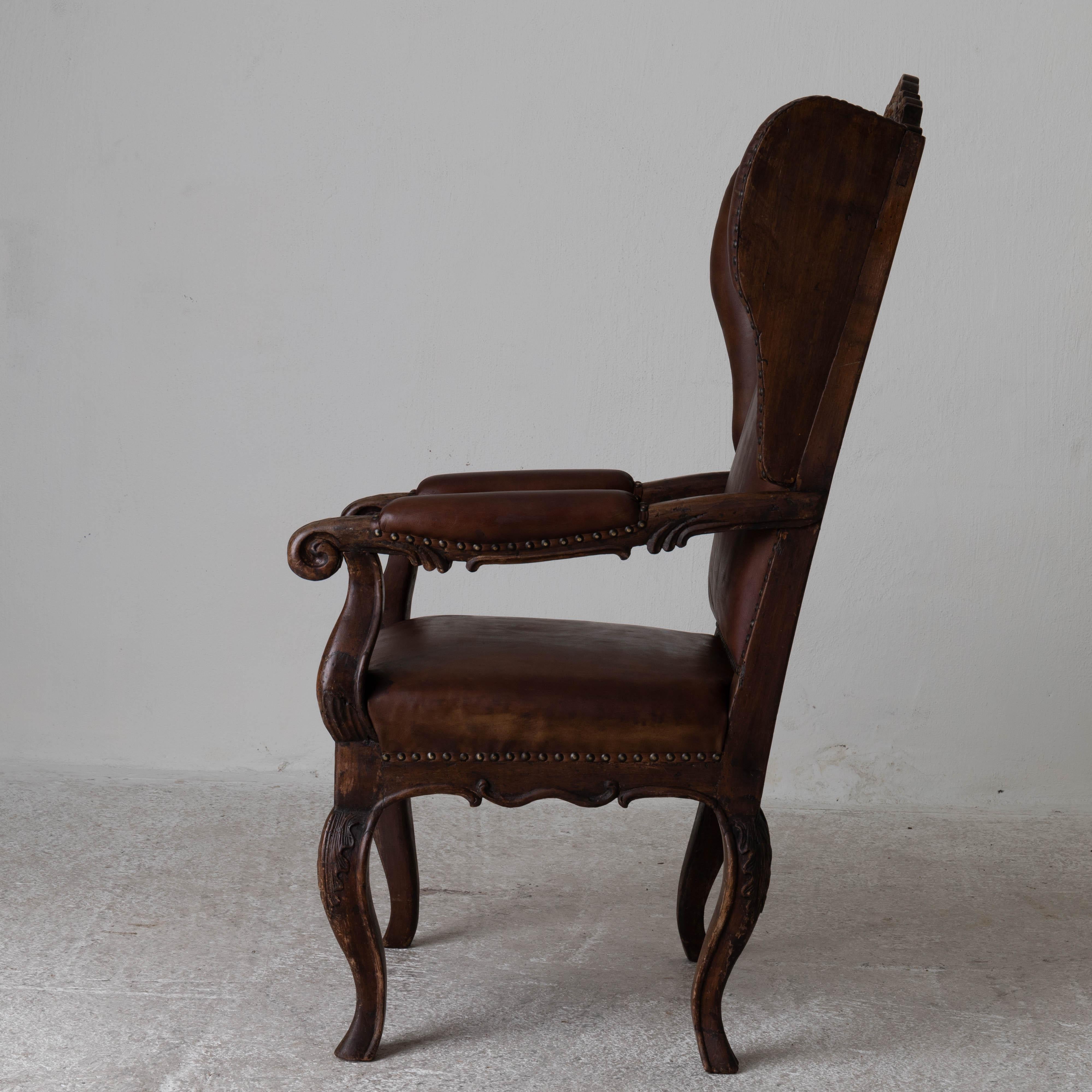 Chair wingback Swedish Rococo Period 1750-1775 Brown Leather Sweden. An exquisite wingback chair made during the Rococo Period in Sweden. Original finish and upholstered in a waxed brown leather. 

 