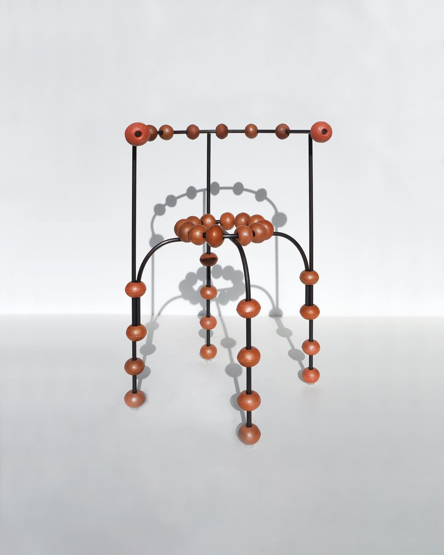 Chair with Buoys by Touch With Eyes
Dimensions: W 40 x D 40 x H 70 cm
Materials: Black metal and buoys. 
Weight: 5 Kg. 

The chair was made with buoys from fishing nets. Moving around Europe in the car in which Touch With Eyes set up their workshop,