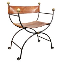 Chair with cast iron frame, gilt brass trim, and brown leather upholstery