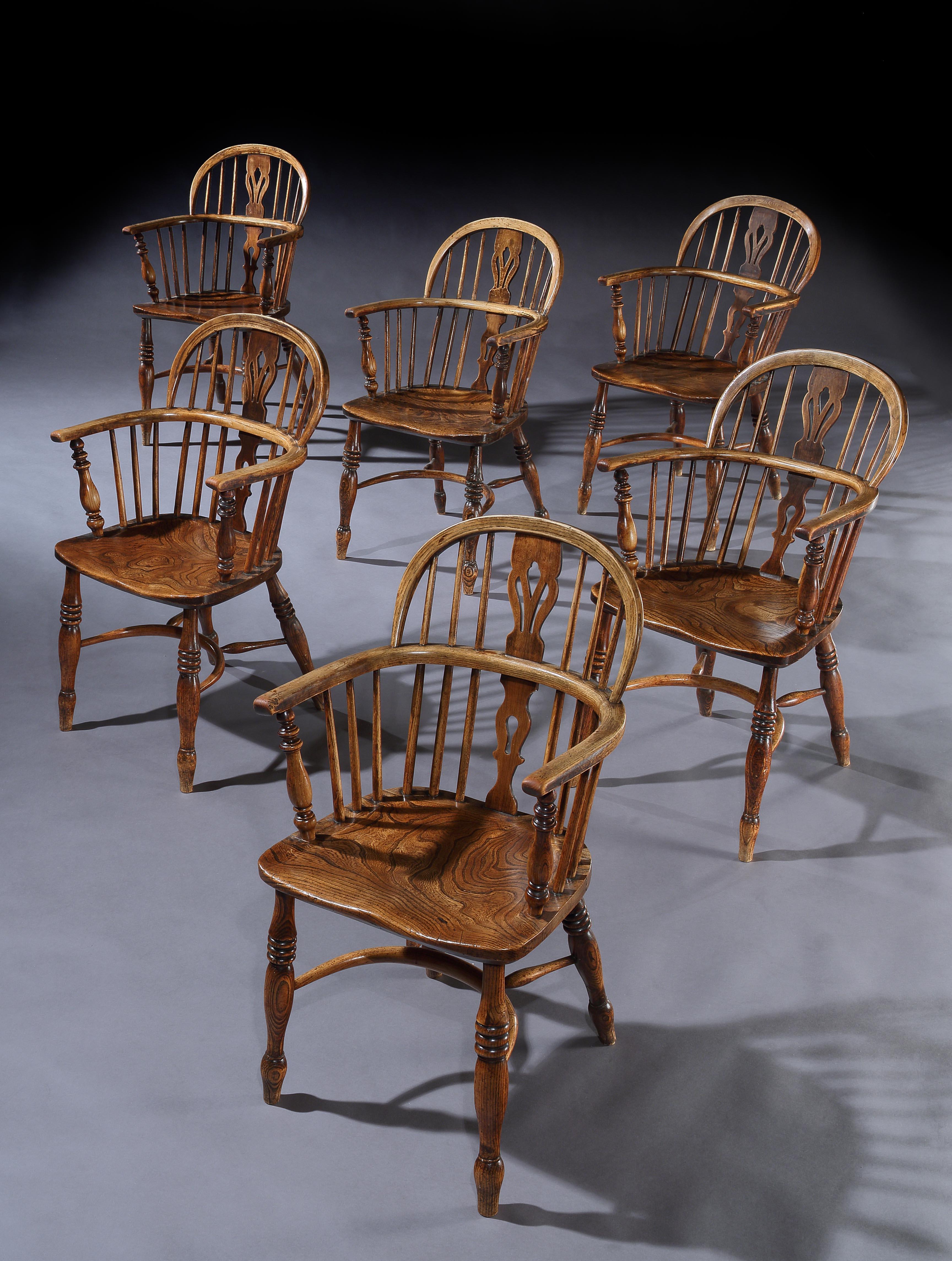 Striking and characterful set of six elm and ash vernacular or folk Windsor armchairs
The yew, elm and ash used have been selected for their exceptional figuring, colour and patina
Fine model with vase splat, hoop back, crinoline stretchers and