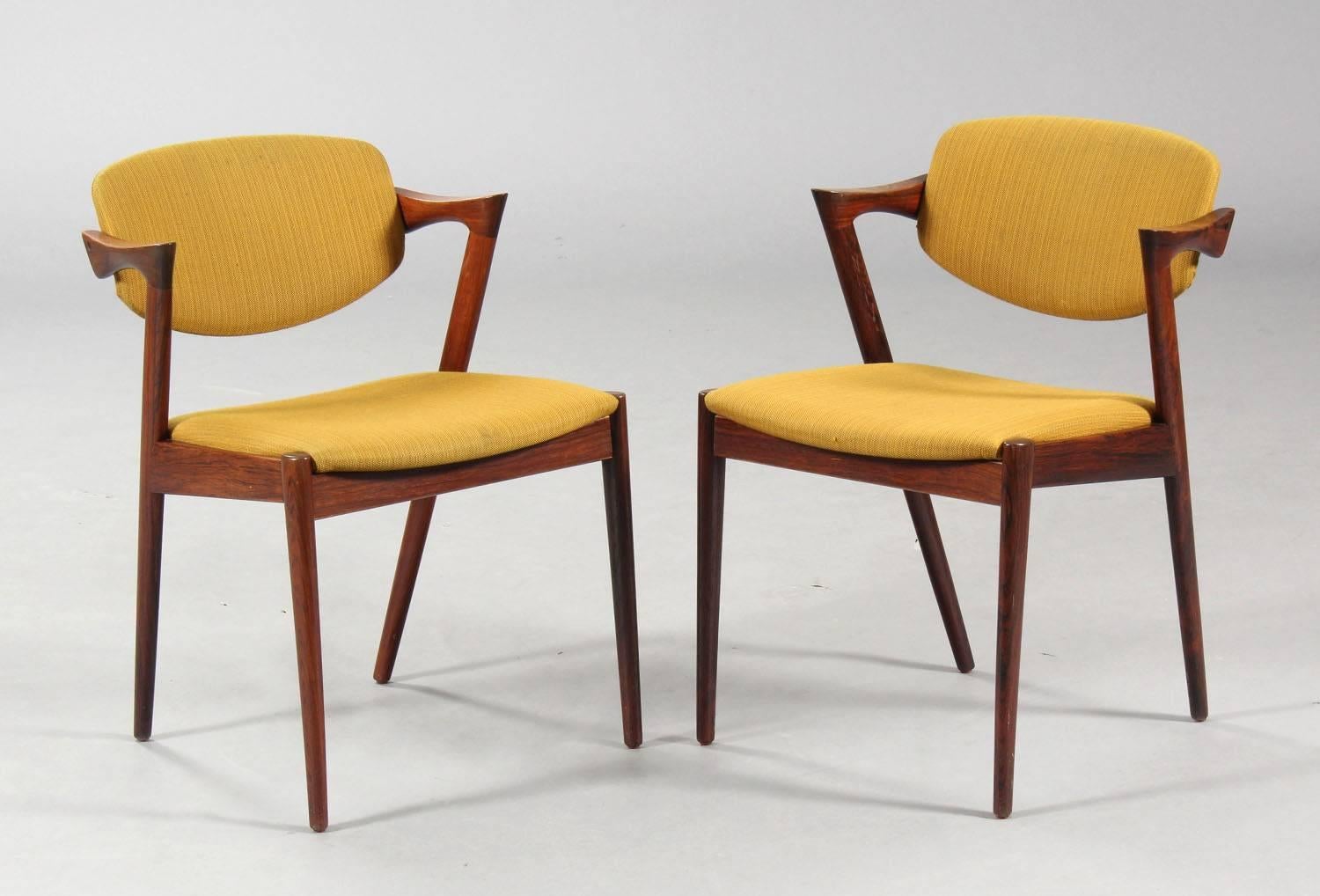 Dining chairs, model 42, designed by Kai Kristiansen and manufactured in Denmark by Schou Andersen Møbelfabrik. The chairs are made from solid hardwood, featuring tapered legs, curved armrests and turquoise wool upholstery. Good vintage