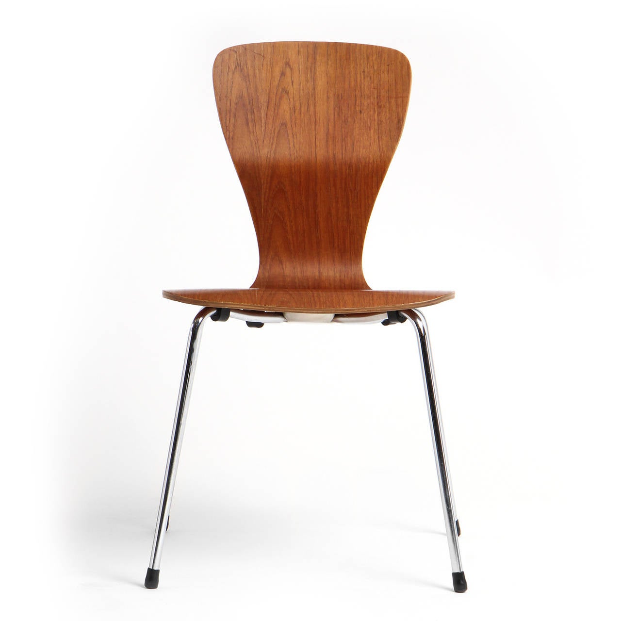 A side chair with a warm-toned undulating laminated teak seat on a chromed steel base.