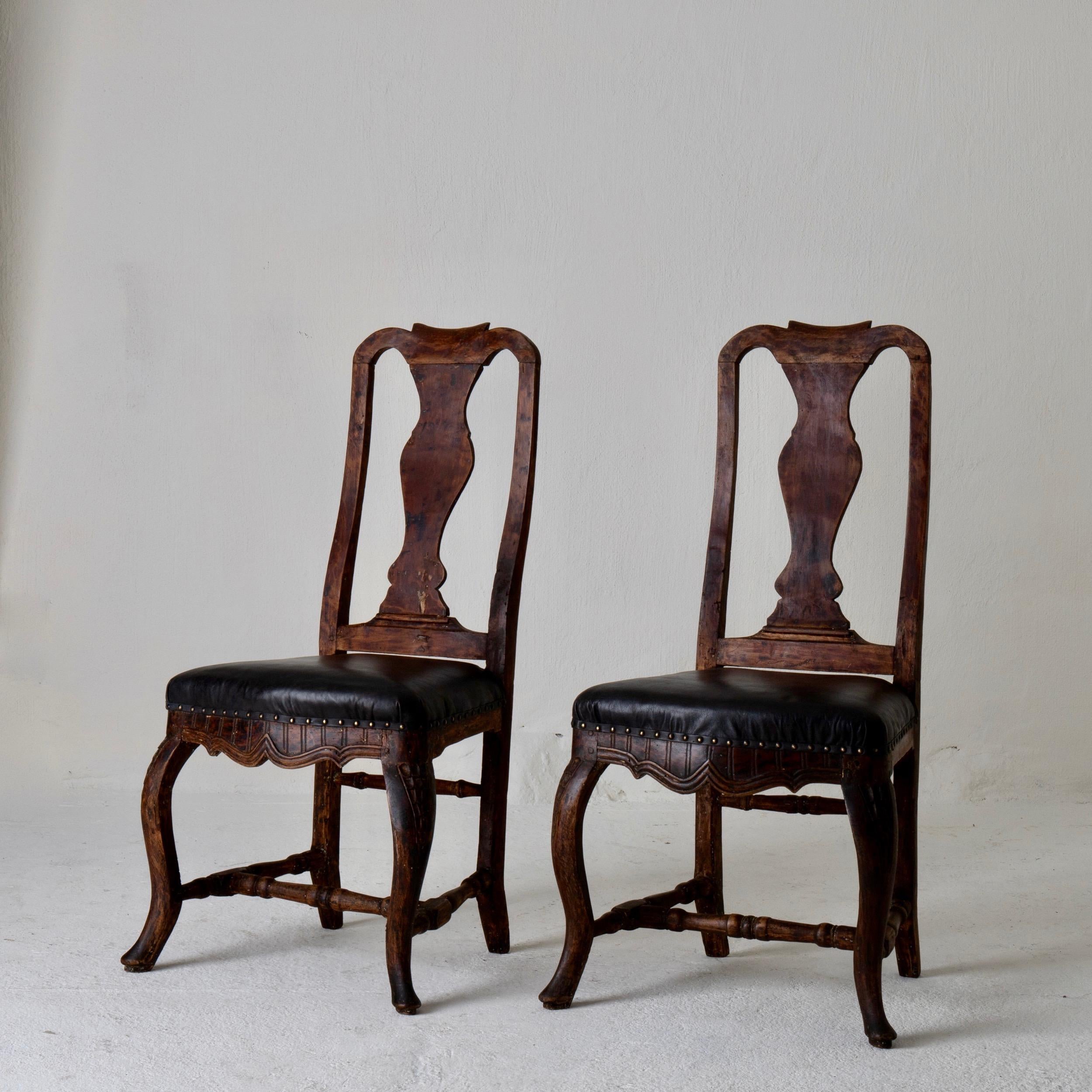 Stühle Paar schwedischen Barock braun schwarz Schweden. Ein Paar Beistellstühle aus der Barockzeit in Schweden. Ein dunkelbrauner Rahmen mit diskreten Schnitzereien. Der Sitz ist mit weichem schwarzem Leder gepolstert und mit Messingnägeln