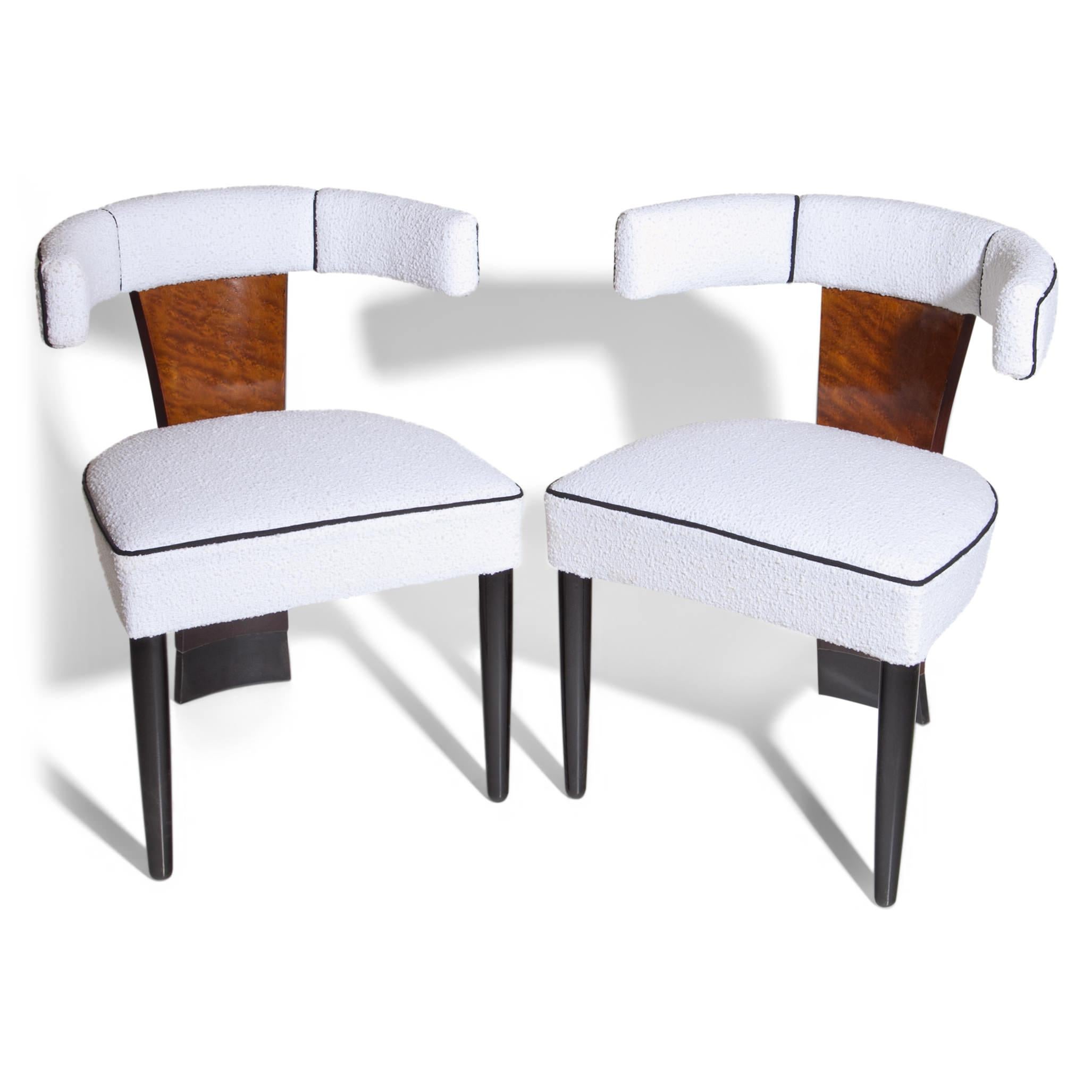Pair of chairs, standing on ebonized tapered legs. The backrest and rear foot is one long piece. The chairs were reupholstered with a white bouclé fabric with black piping.