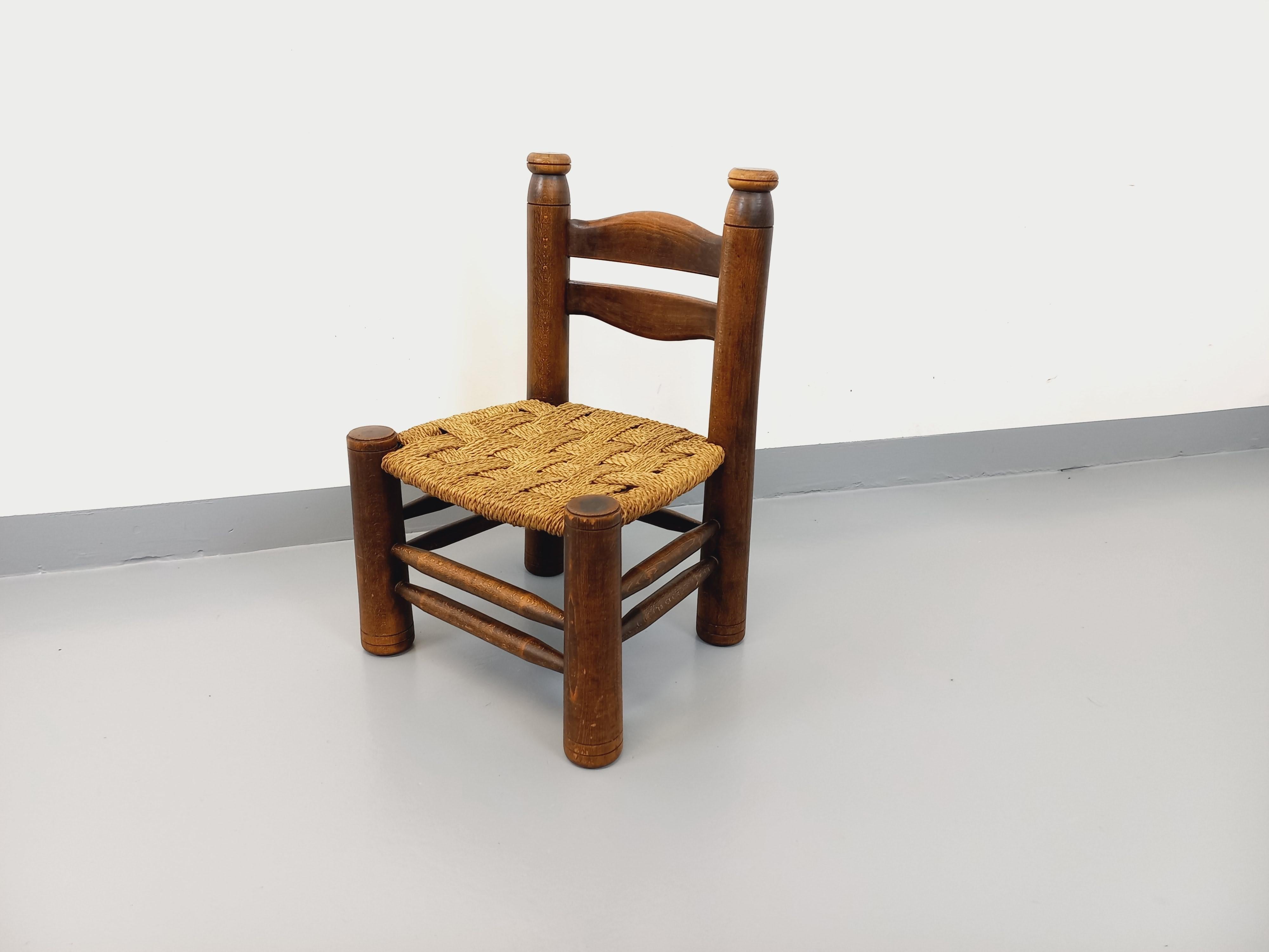 Chaise basse brutaliste vintage, très beau design attribué à Charles Dudouyt, dans le goût de Charlotte Perriand, style chalet rustique, en bois et assise paillée. Chaise basse type chaise d’appoint ou chaise décorative ou chaise d’enfant. Très bon
