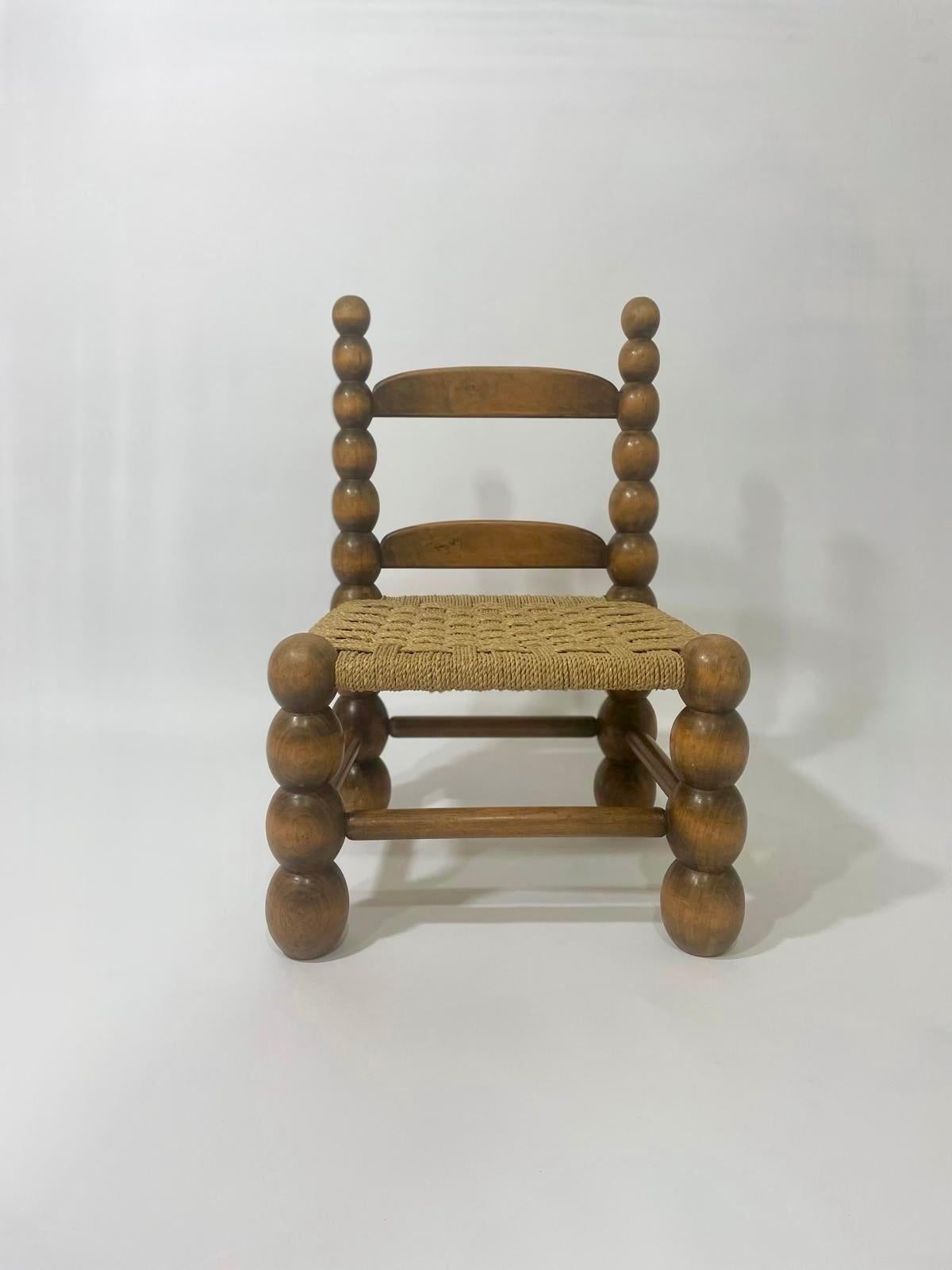 Chaise basse en chêne massif tourné et cordes tressées dans le style de Charles Duduouyt, années 1950, France. Chaise solide et stable en bon état tant au niveau de la structure et de l'assise tressés en cordes de qualité. Patine et traces minimes