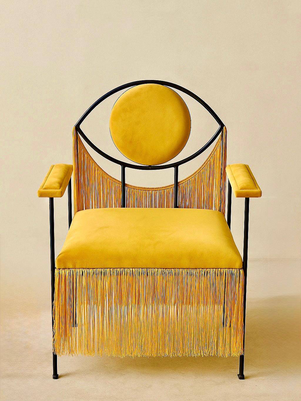Sa structure métallique assure solidité et légèreté, tandis que l'assise et le dossier, habillés de velours frangé, apportent une touche raffinée et texturée. Confortable et enveloppante, l'assise invite à la détente, sublimée par les franges qui