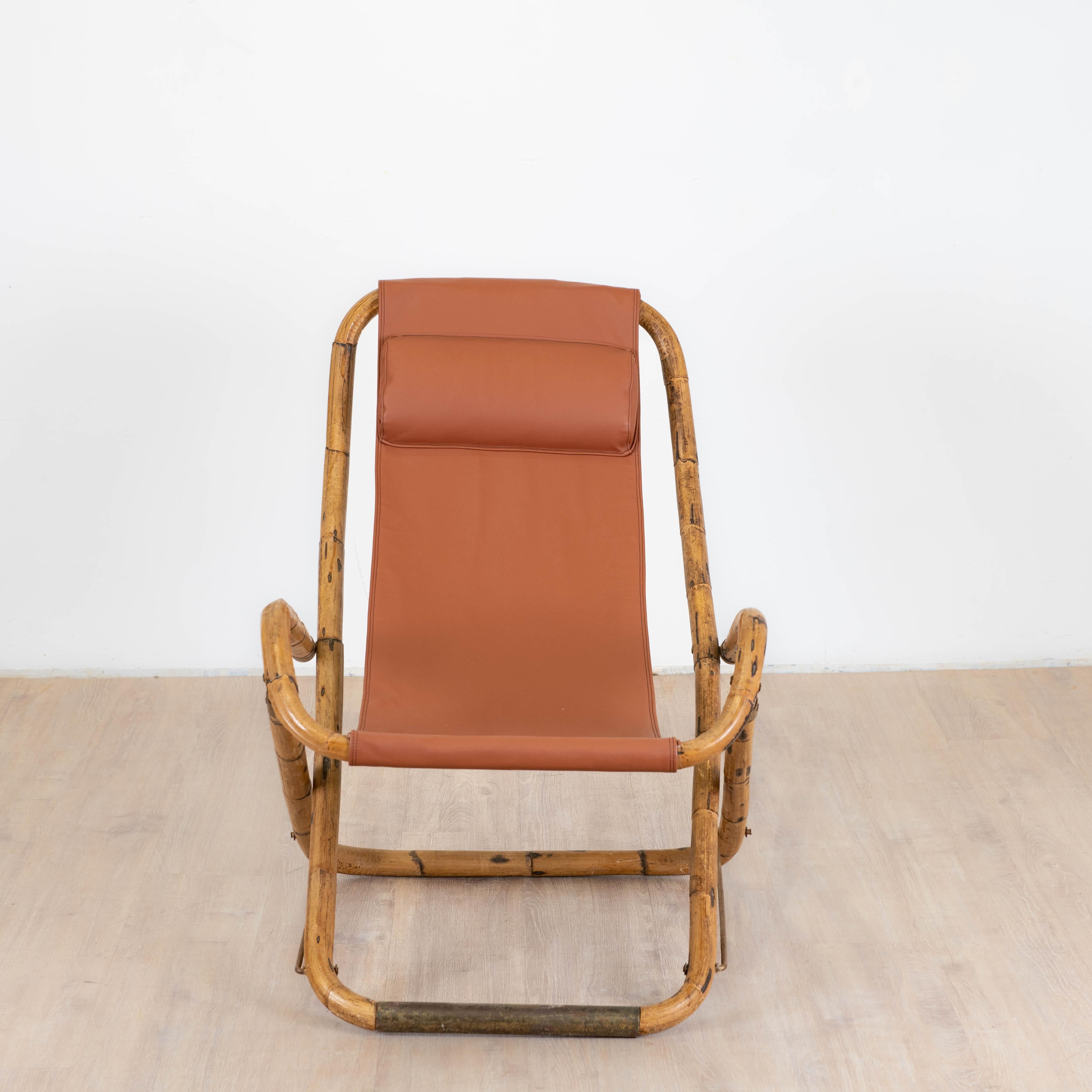 Transat de fabrication italienne des années 1960 la chaise longue pliante est en bambou plié, les charnières, les protection en contact du sol sont en laiton patiné par le temps. L'assise nouvellement retapisser avec un appuis tête rembourrer est