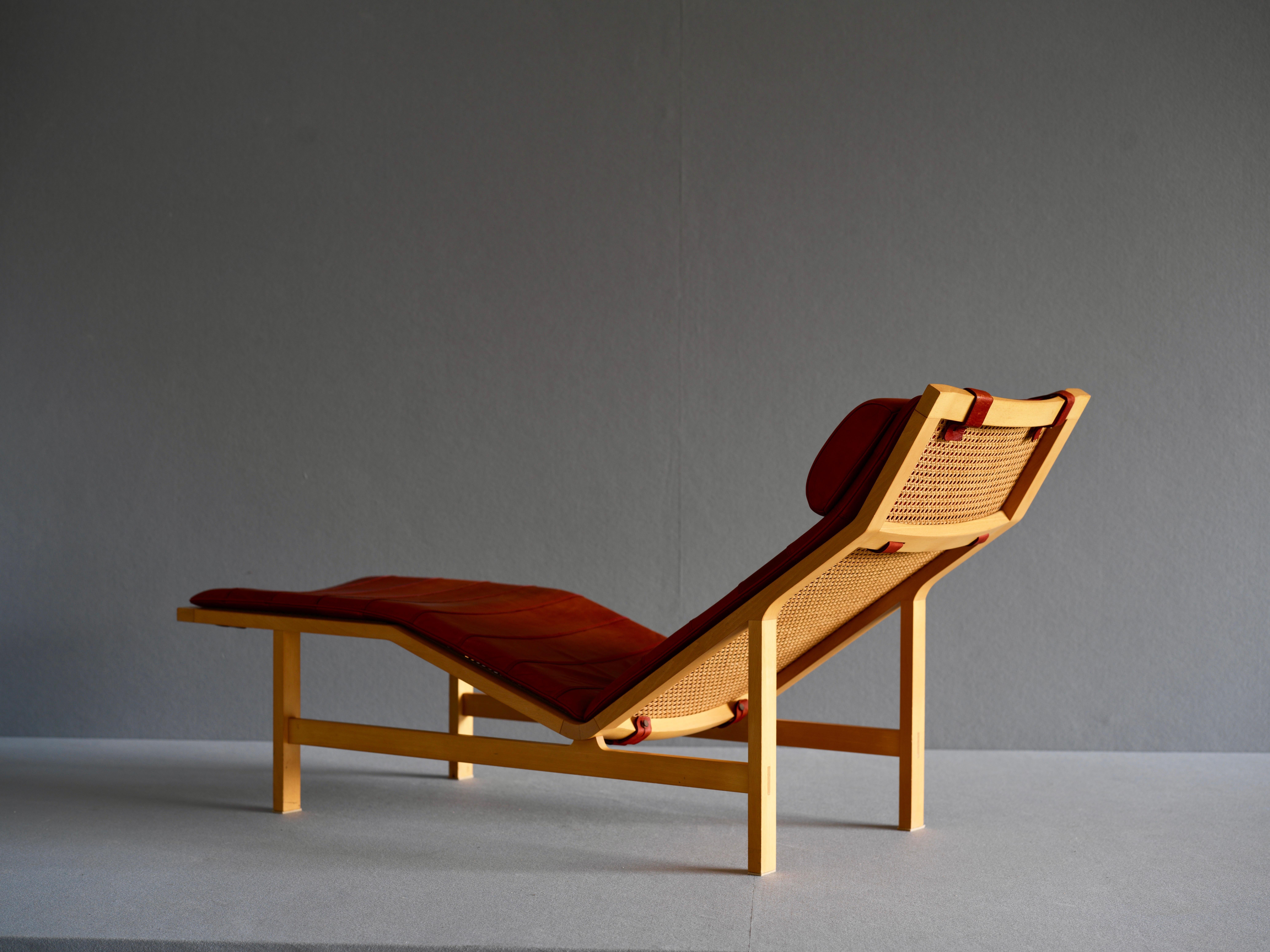 Chaise lounge by Rud Thygesen and Johnny Sorensen. This is known as the “Escape Chair”. It is in solid ash and has a back and seat in French wicker. The cushion and headrest is upholstered in brown leather.

 