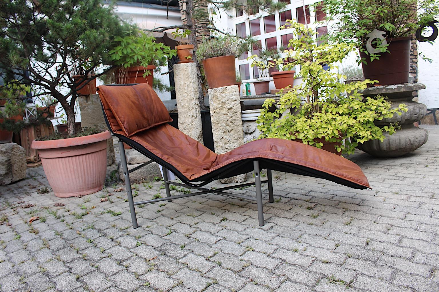 Modern freestanding vintage chaise longue or daybed from brown stitched leather and metal by Tord Bjorklund, 1970s Sweden.
A stylish and very comfortable chaise longue or daybed from metal with a loose cushion from thick stitched leather in cognac