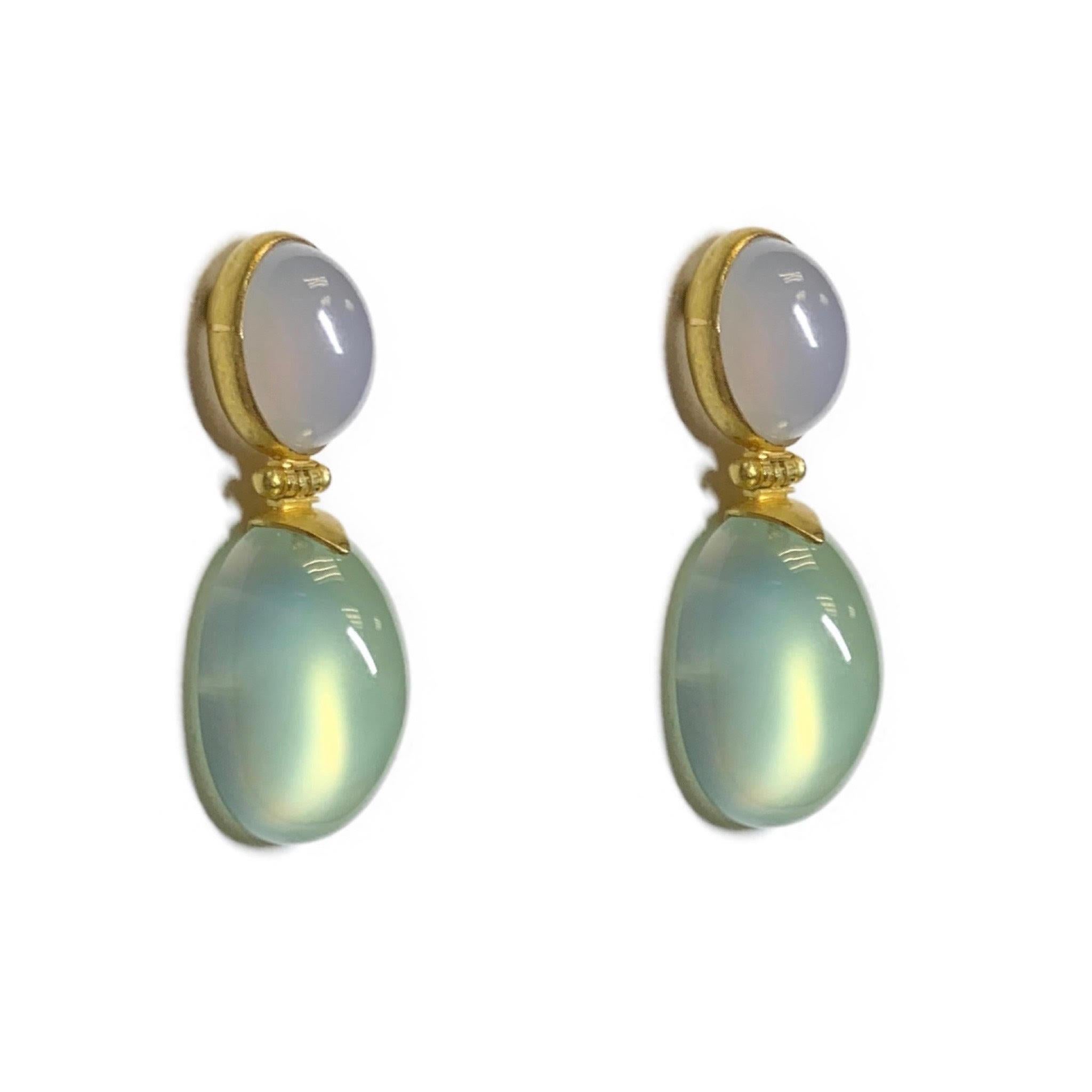 These dangle pair of earrings have two stones Chalcedony and Prehnite that go together wonderfully. Both stones are Cabochon cut and are connected by an 18 Karat Yellow Gold hinge. 
Chalcedony is a form of quartz. It is considered a powerful healing