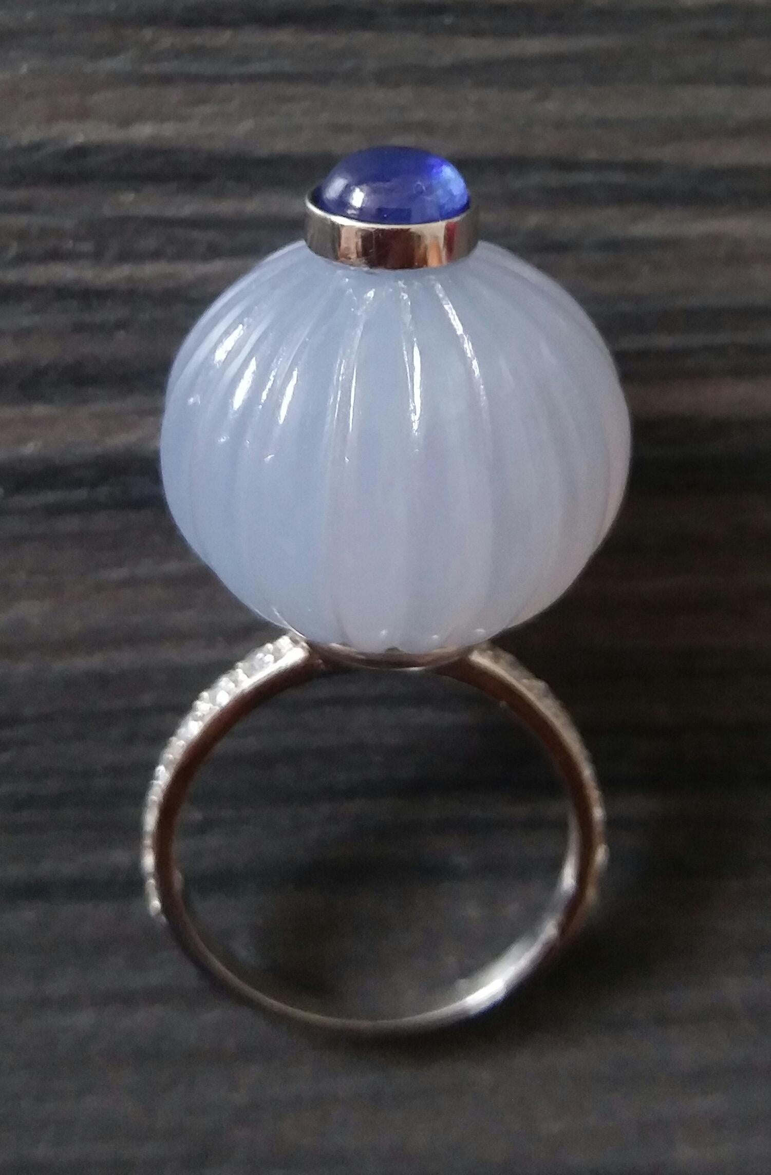 
Melon cut Chalcedony Round Bead of 20 mm. in diameter and 16 mm. thick with in the center a round Blue Sapphire cabochon of 7 mm. in diameter set in 14 kt white gold is mounted on top of a 14 Kt. white gold and 14 diamonds shank ( actual size #7,