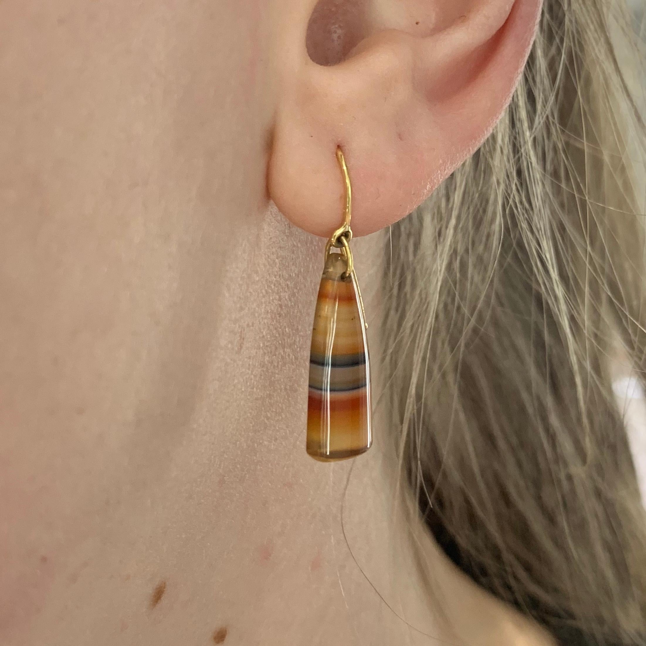 A fine pair of carved Indonesian chalcedony earrings set on 9ct gold hooks. The chalcedony has a beautiful multi coloured striped finish which depicts the colours and tones from a sunset.

These look beautiful when worn and can be dressed up or