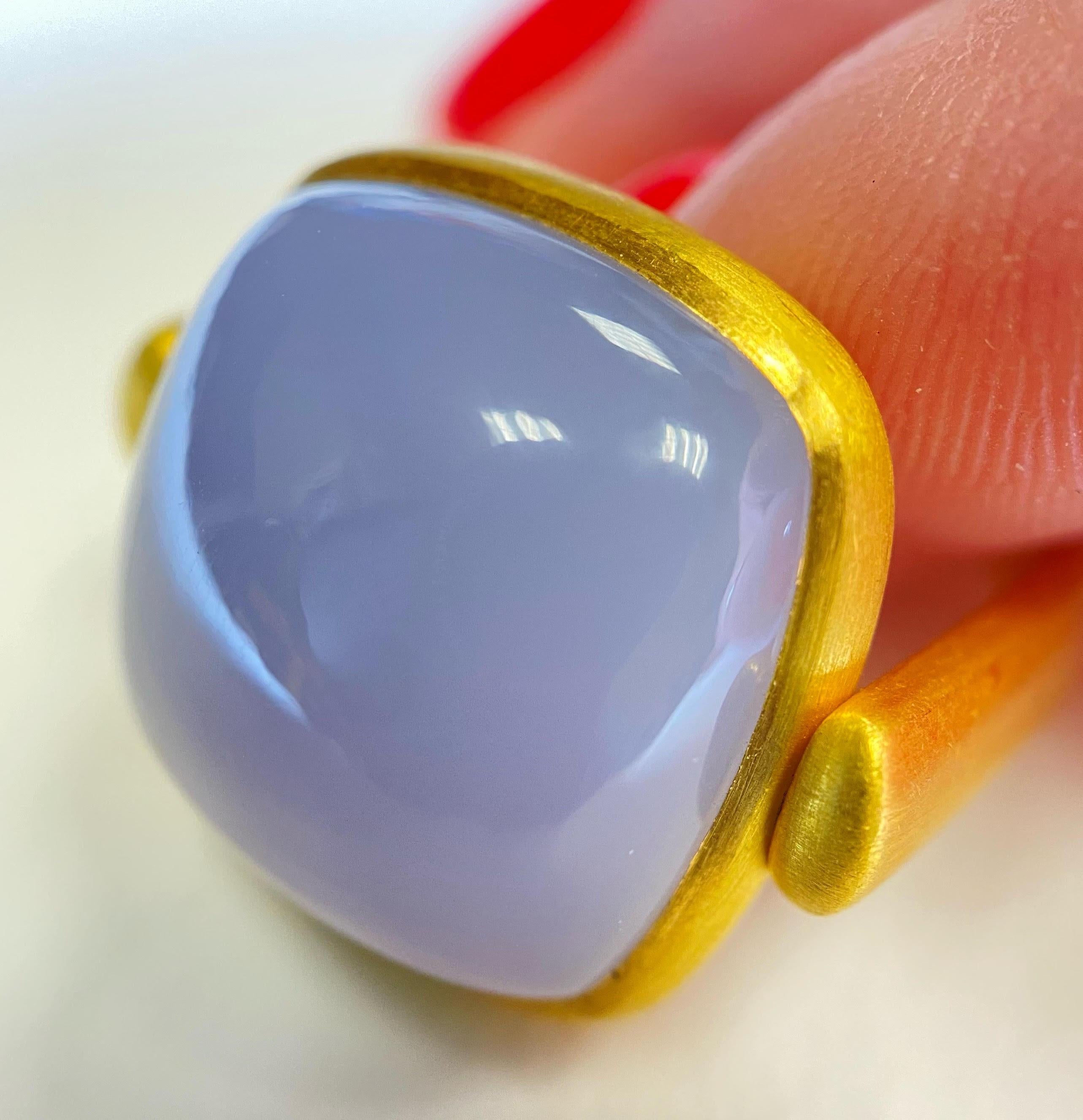 This playful cocktail ring is made of 22 karat yellow gold and features a large cabochon cut Chalcedony. The center stone swivels independently from the ring as a design feature. The finish on the gold is a soft satin finish, adding to the