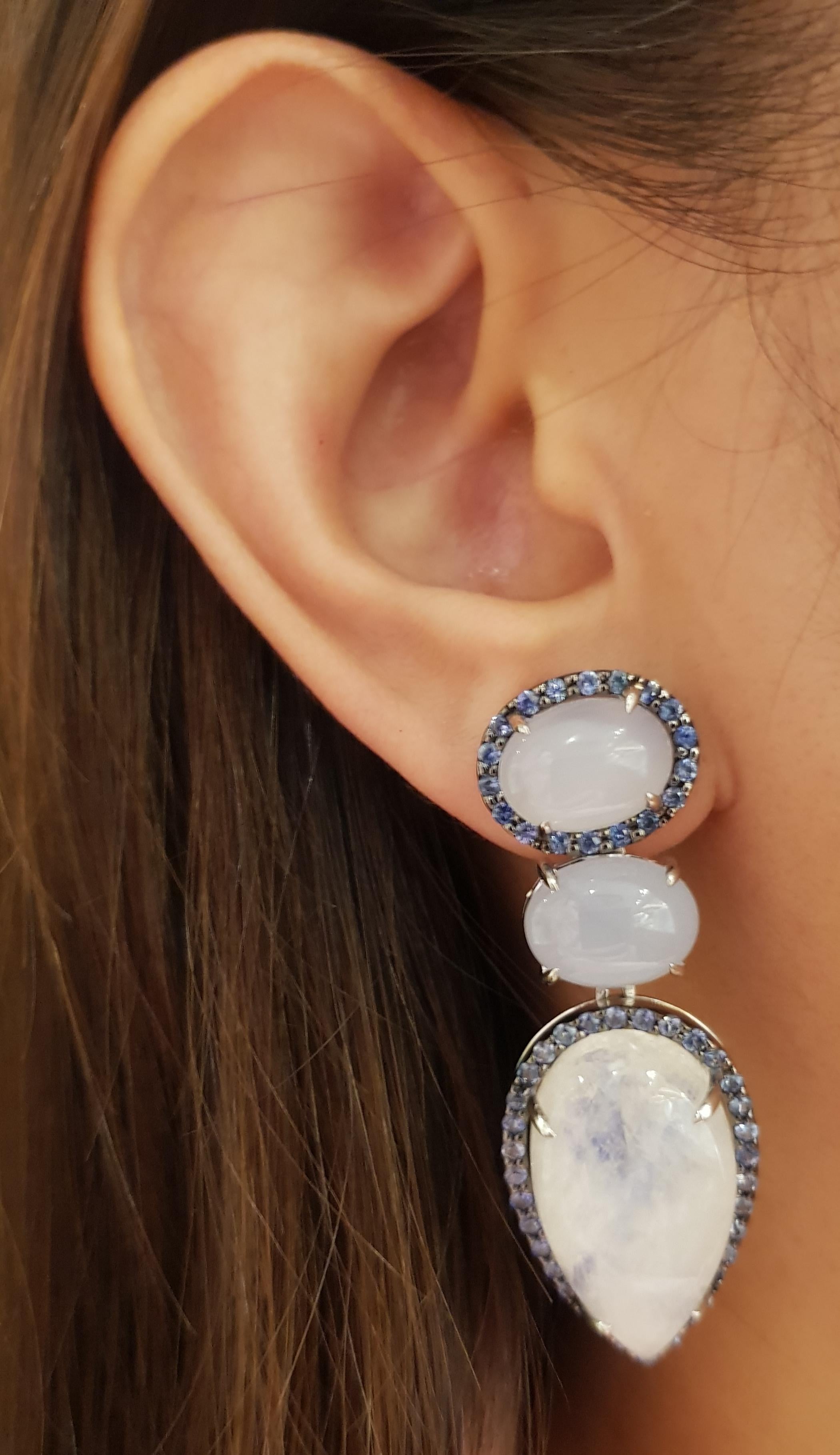 Chalcedony, Moonstone and Blue Sapphire Earrings set in Silver Settings

Width: 1.8 cm 
Length: 5.0 cm
Total Weight: 24.56  grams

*Please note that the silver setting is plated with rhodium to promote shine and help prevent oxidation.  However,